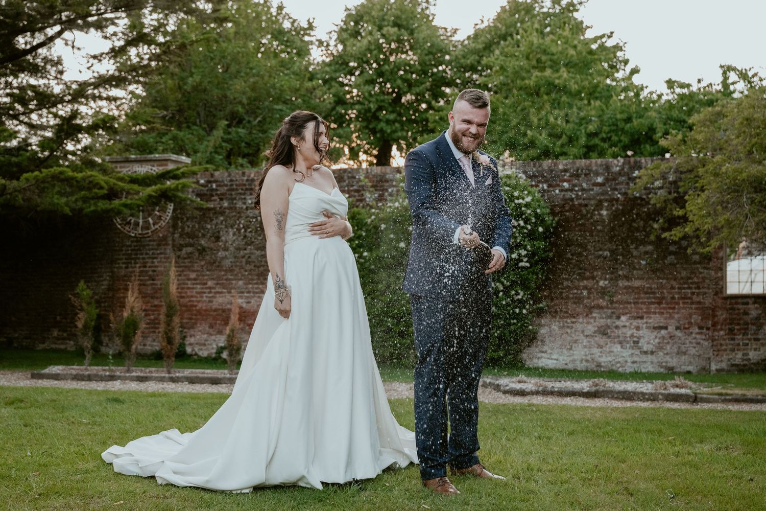 Wedding celebration with confetti toss in a lush garden setting.