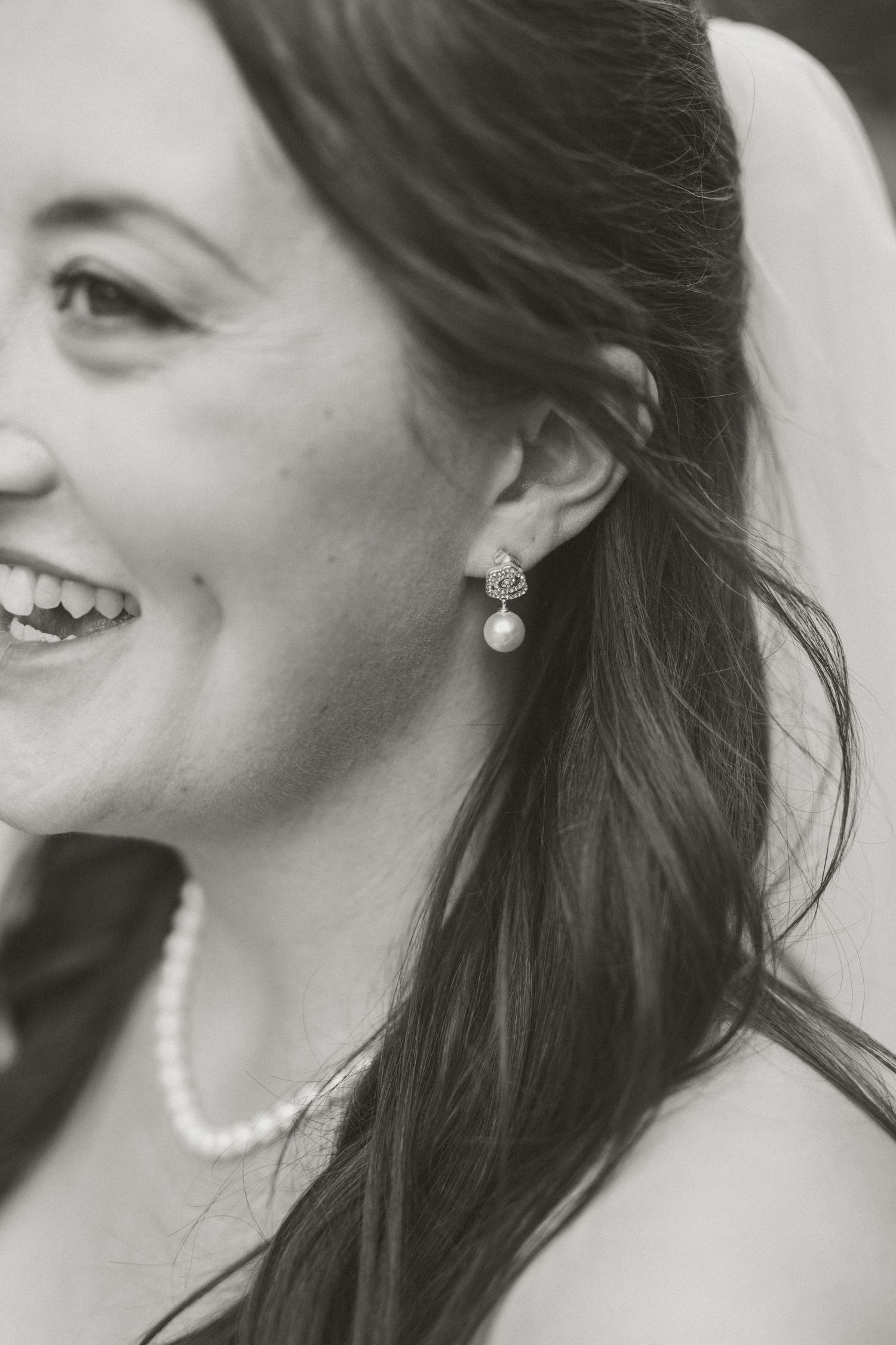Black and white portrait showing elegant pearl jewelry and natural hair styling.