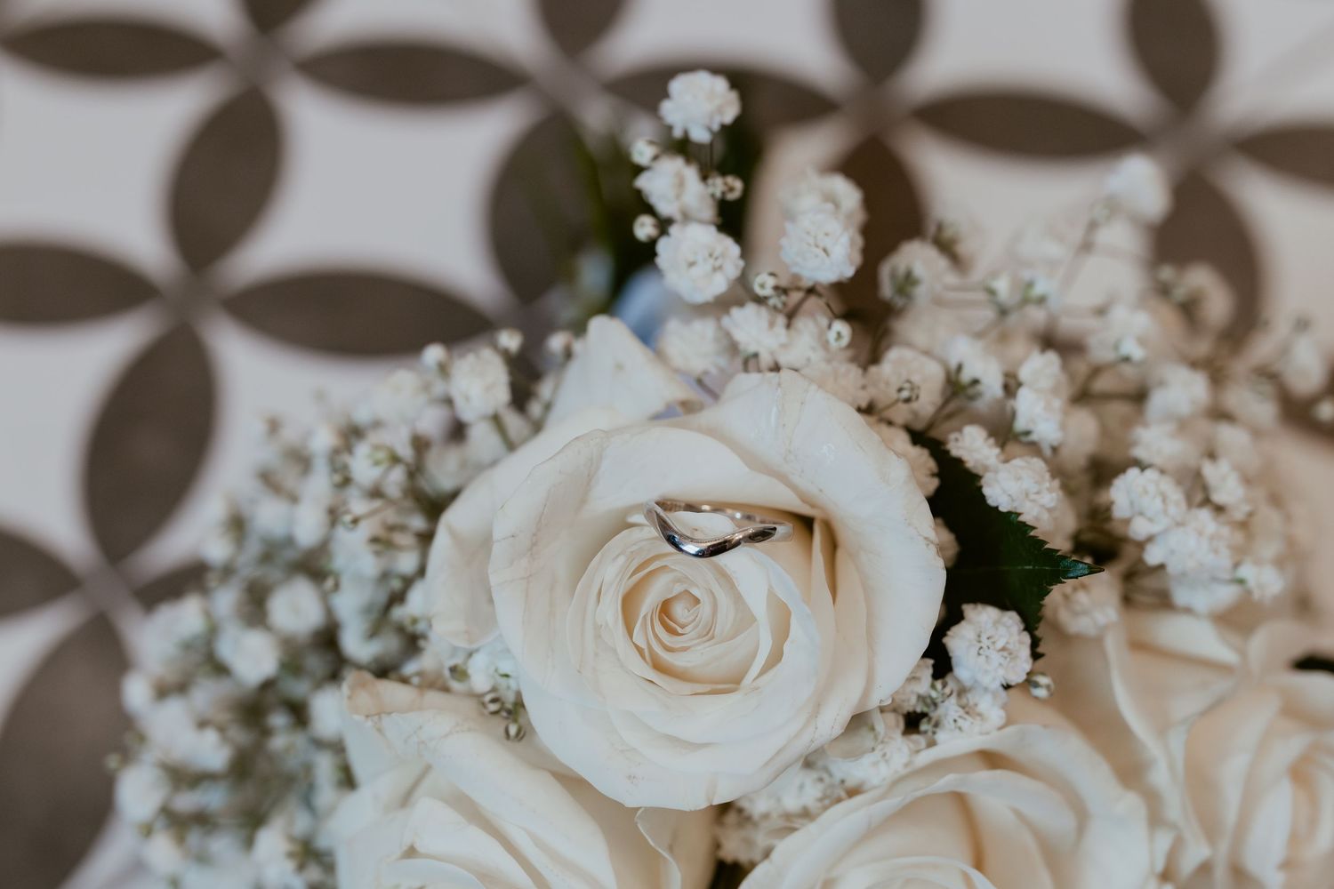 Delicate white roses and baby's breath flowers arranged in a romantic wedding bouquet.
