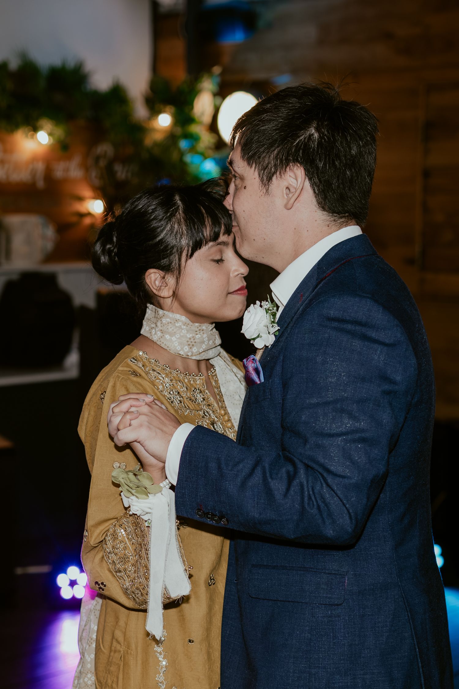 Couple sharing romantic moments during evening wedding reception.