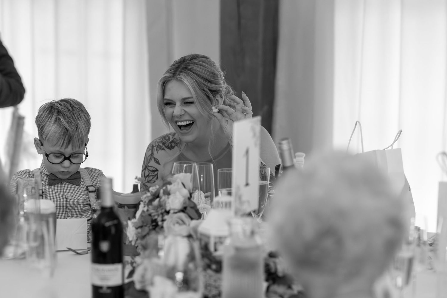 Wedding reception guests mingling and celebrating in a bright indoor venue.