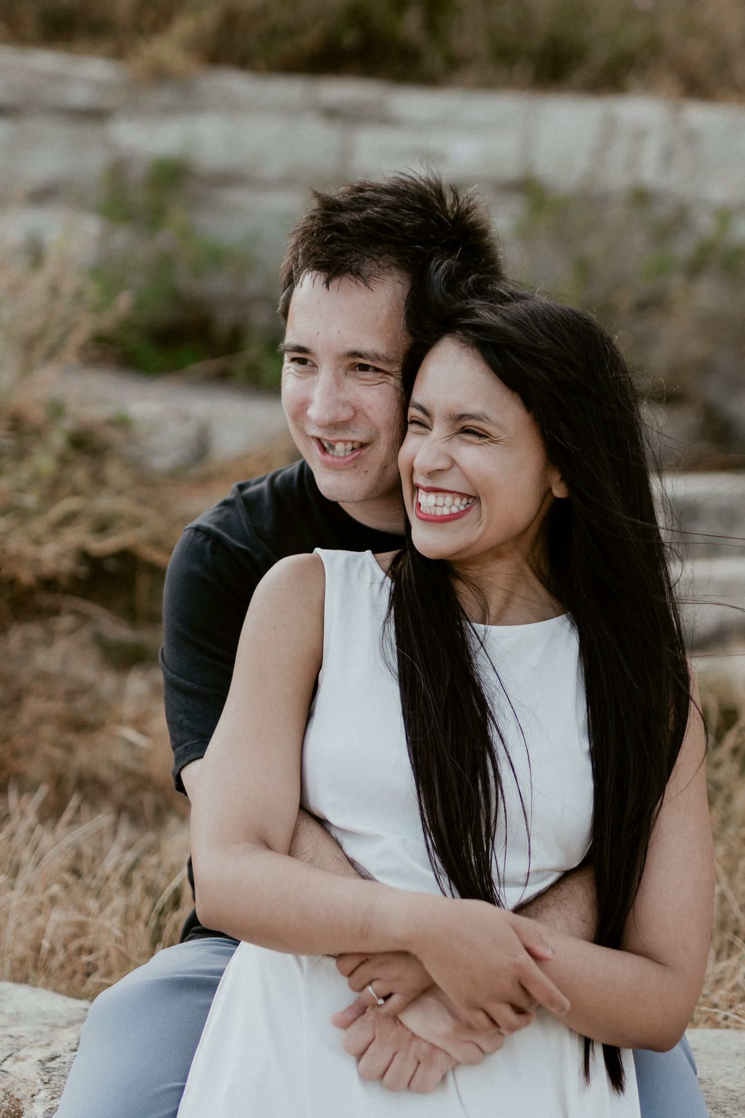 Candid series of a couple embracing and laughing together in natural outdoor lighting.