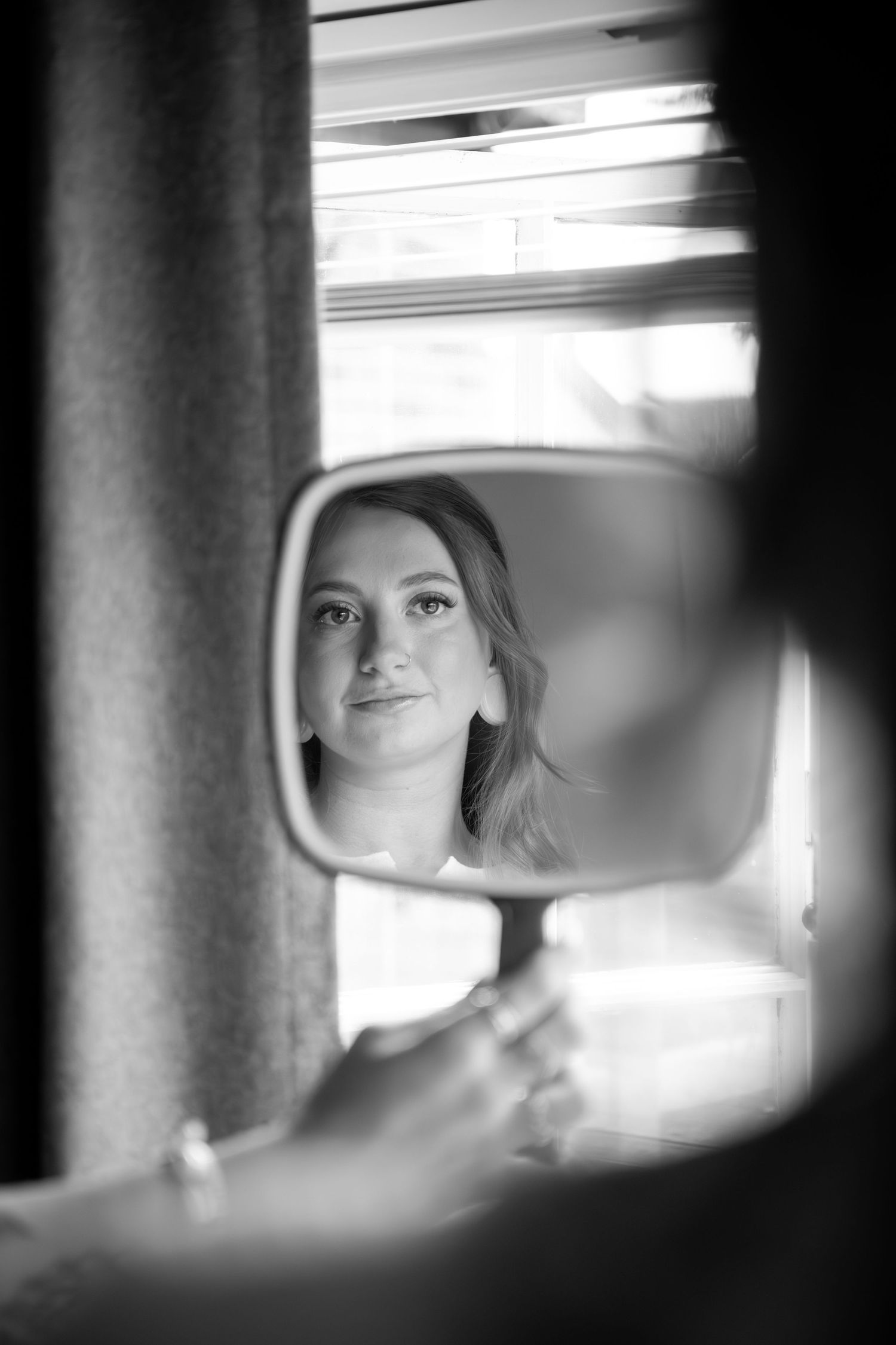 A series of black and white reflections in car mirrors showing glimpses of a figure in soft, ethereal lighting.