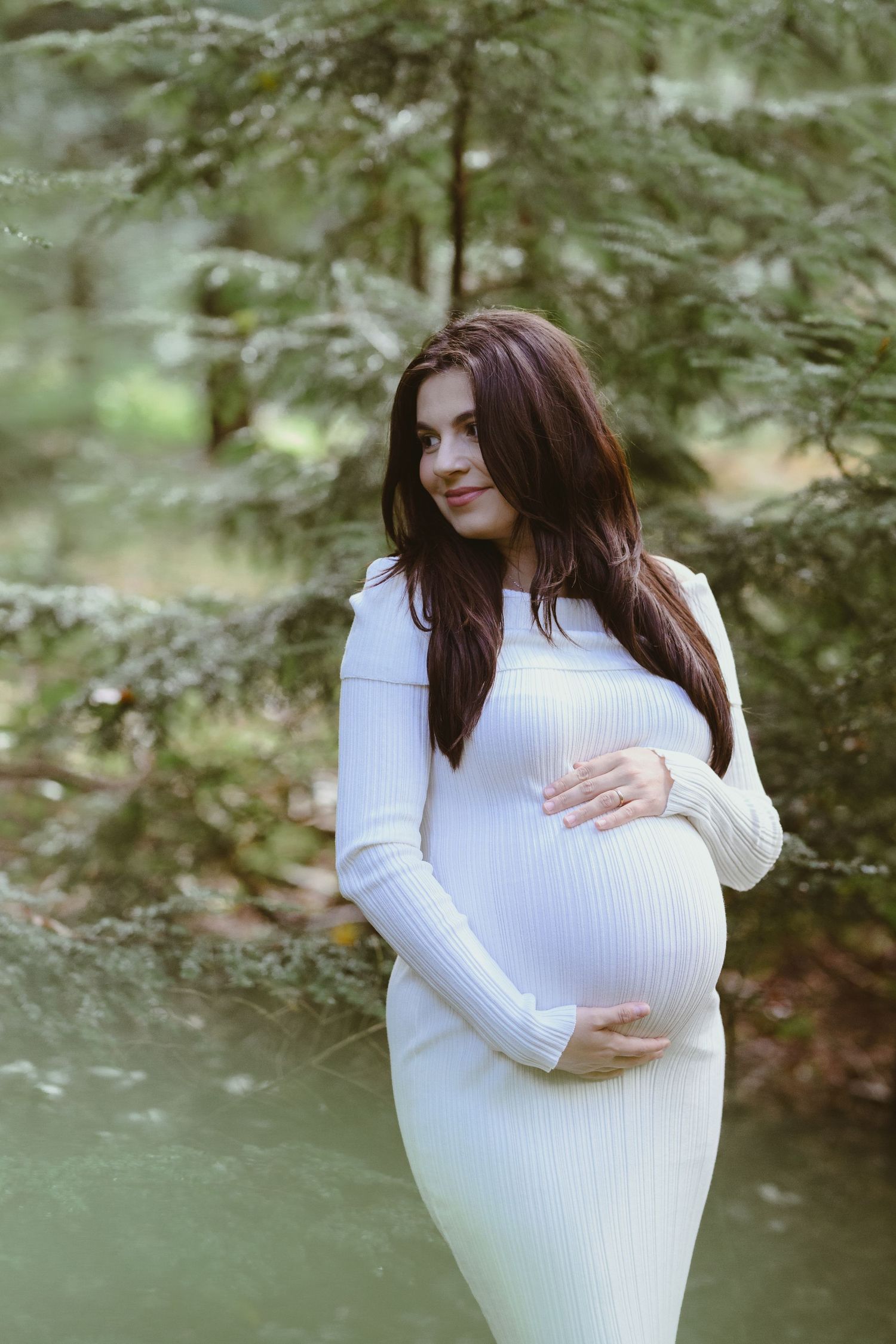 Intimate maternity portraits showing gentle moments in a serene forest backdrop.