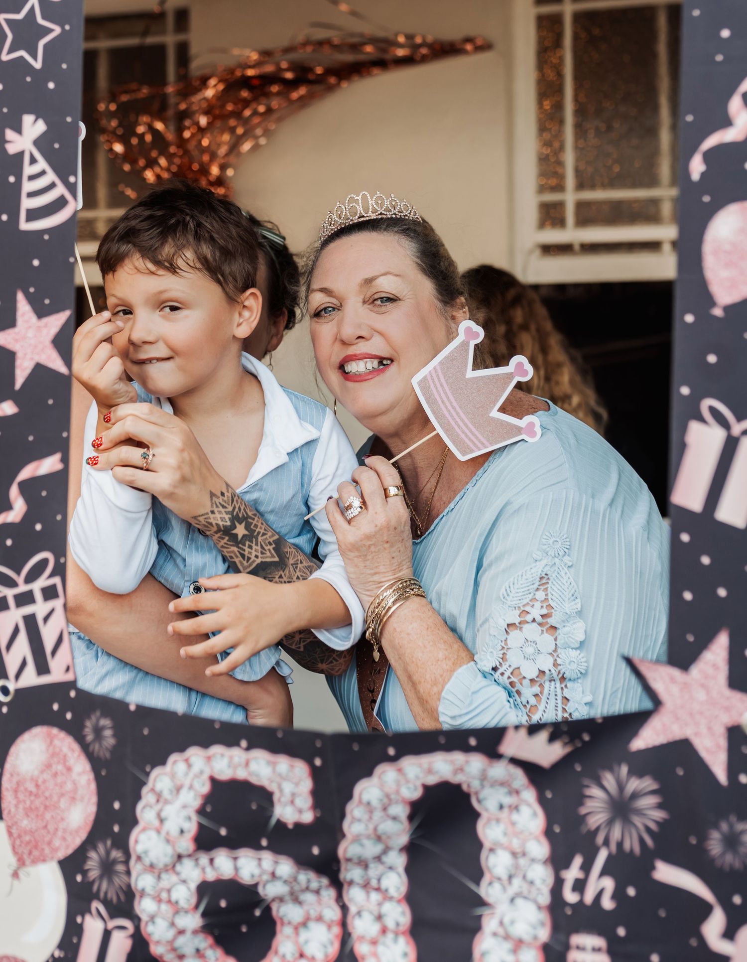 A celebratory 60th birthday party moment with decorative photo props and festive background.