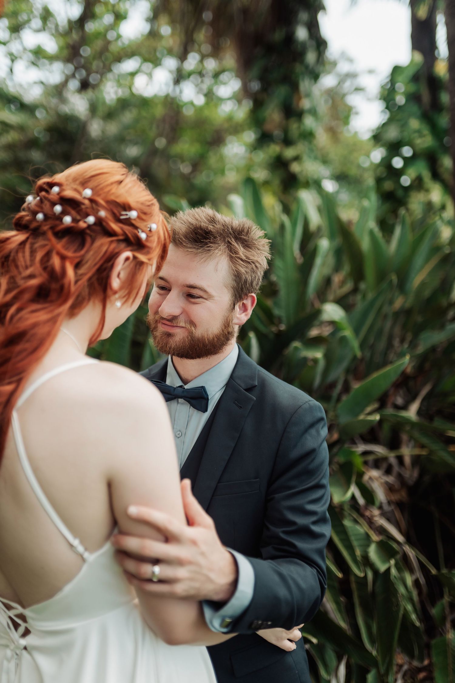Intimate wedding portraits with tropical foliage creating a natural backdrop.