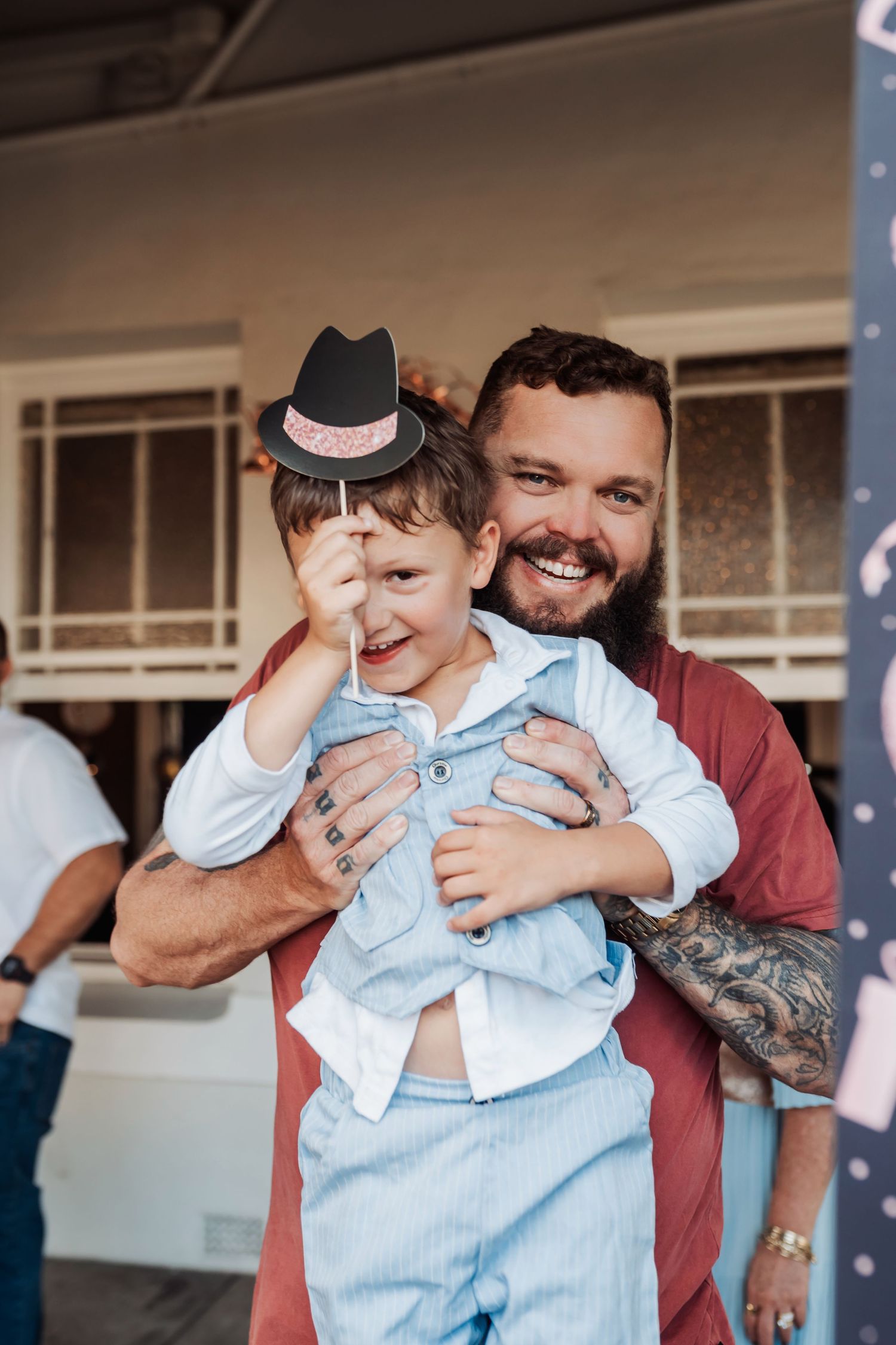 A playful moment at a party with a small fedora hat prop.
