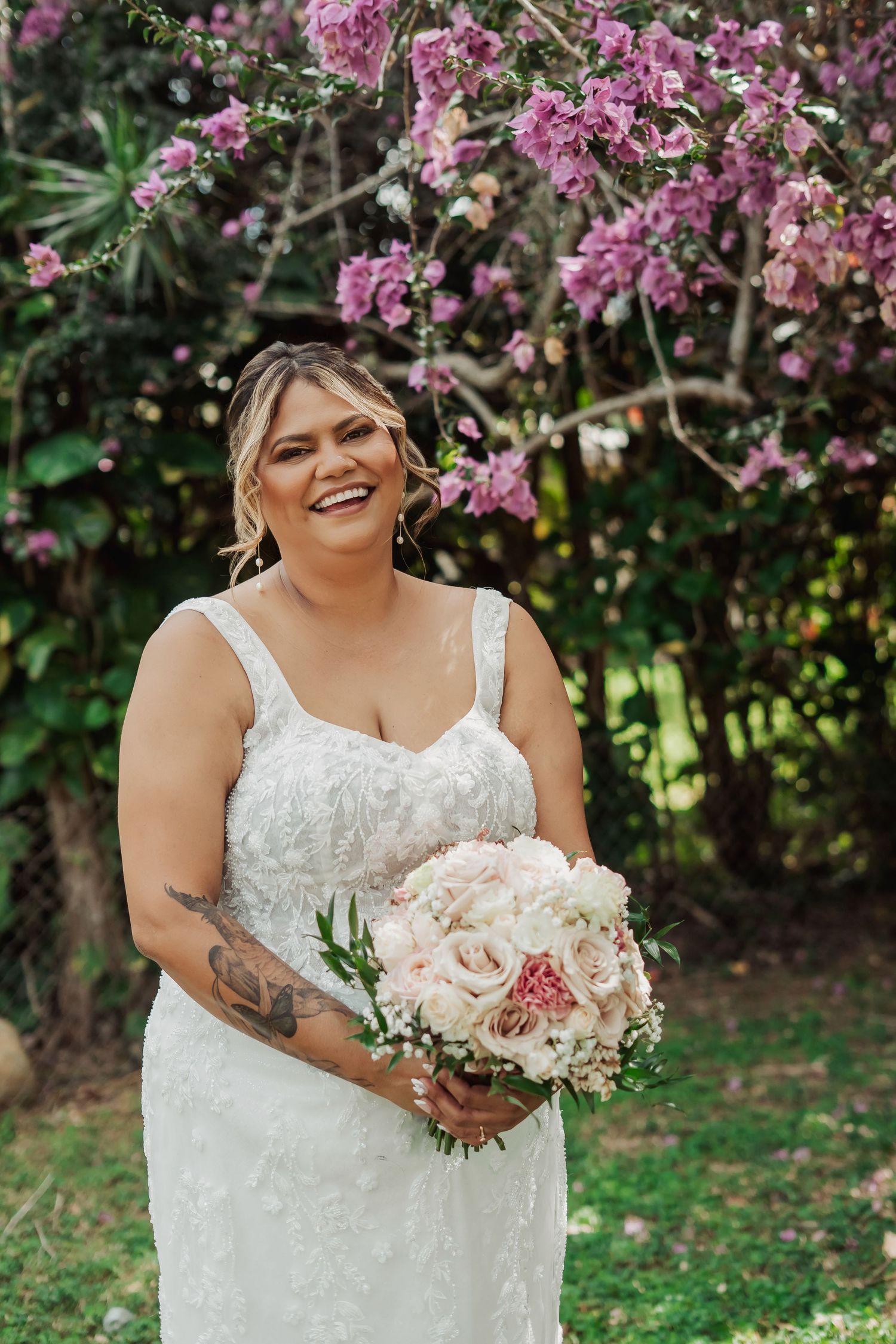 Beautiful spring wedding scene with pink cherry blossoms and a white lace dress against a natural garden backdrop. Cairns