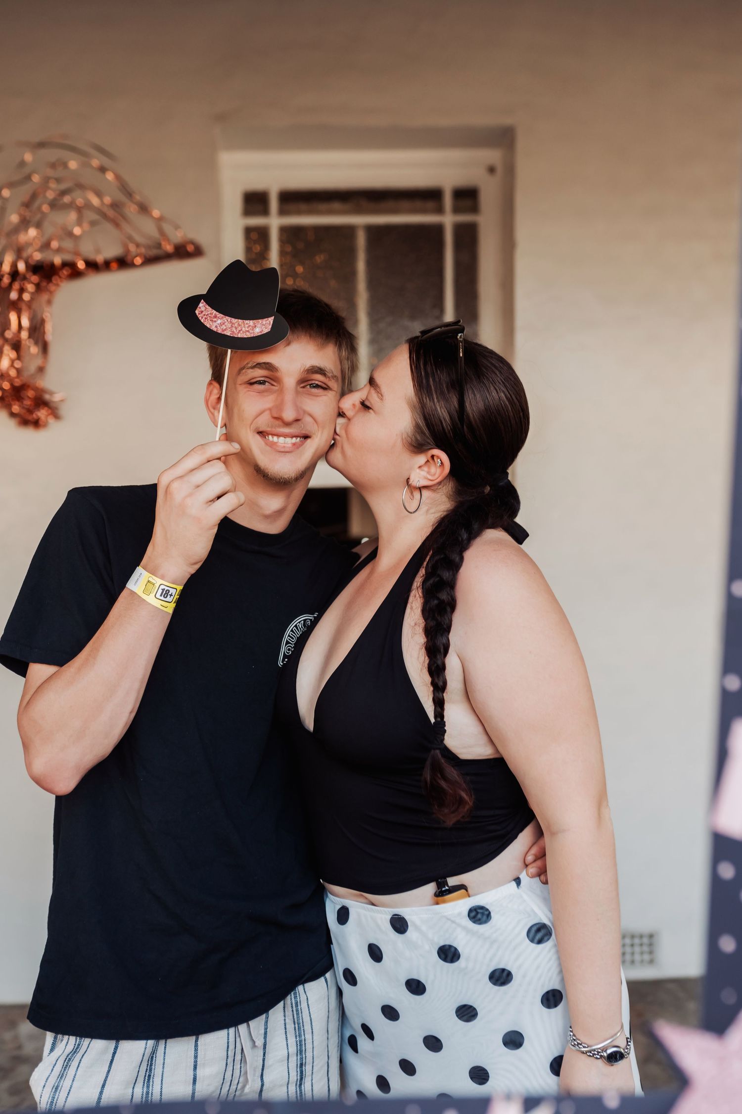 A sweet moment captured at a party with decorative props and polka dot clothing. Ingham
