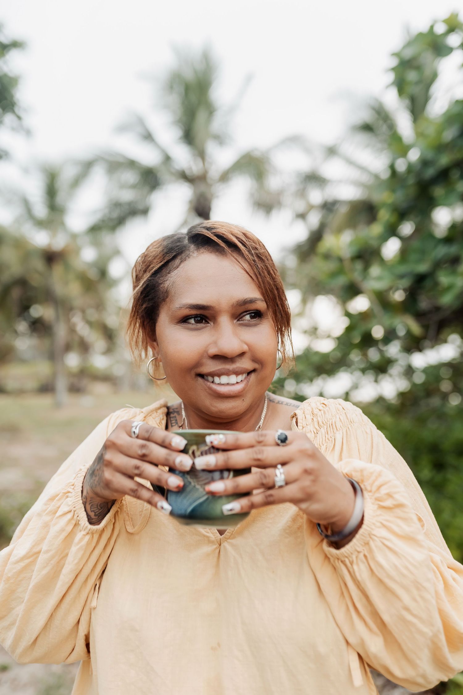 Casual outdoor portrait session with jewelry and a peach-colored top.