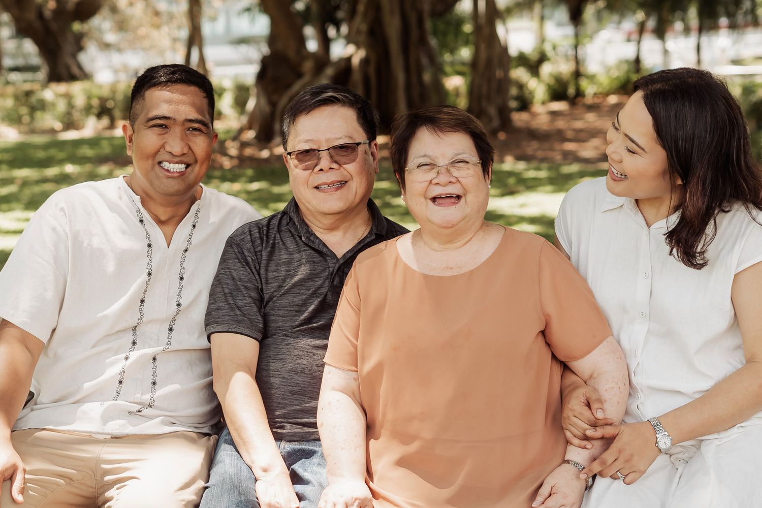 Extended family members share joyful moments together during an outdoor photo session.