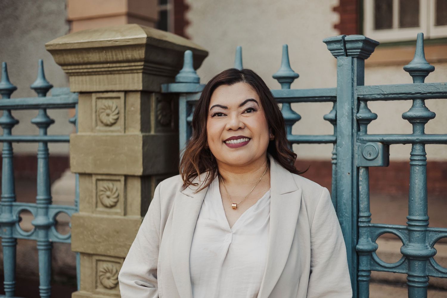 Fashion portrait featuring beige blazer and architectural details.