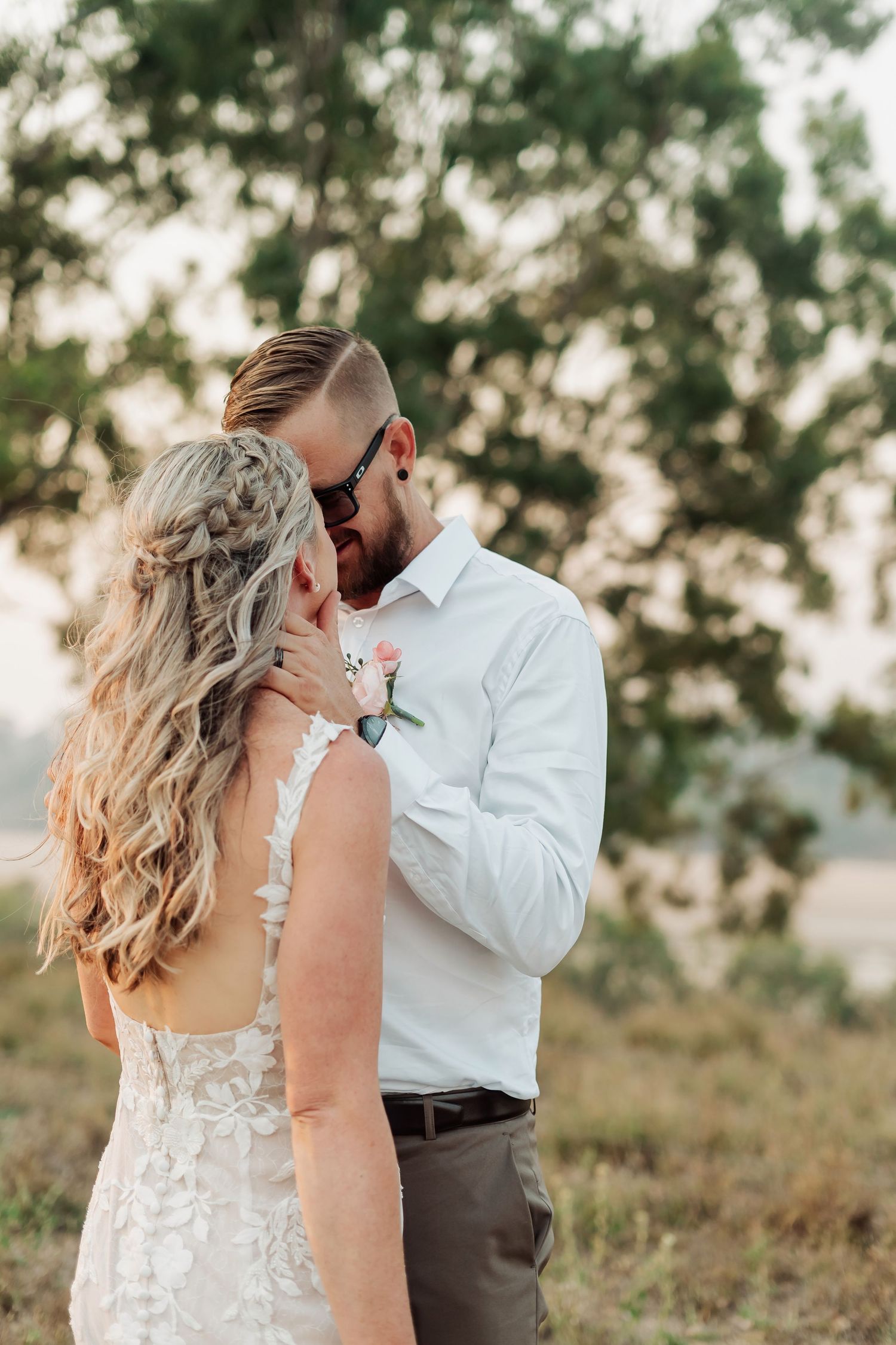 Romantic sunset wedding portraits showing tender moments between a couple in a natural setting.