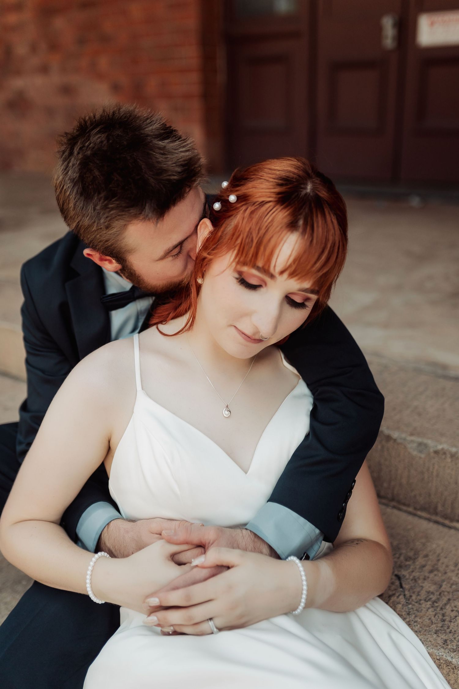 An intimate wedding photo session on brick steps with gentle embraces.