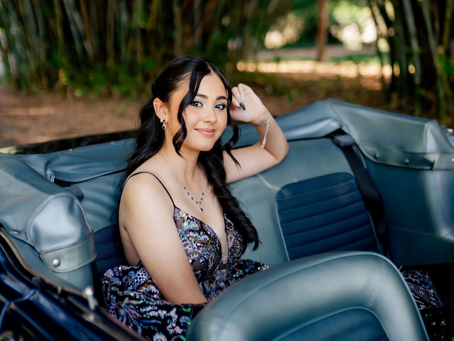Elegant photoshoot featuring a sparkling formal dress in a vintage car setting.
