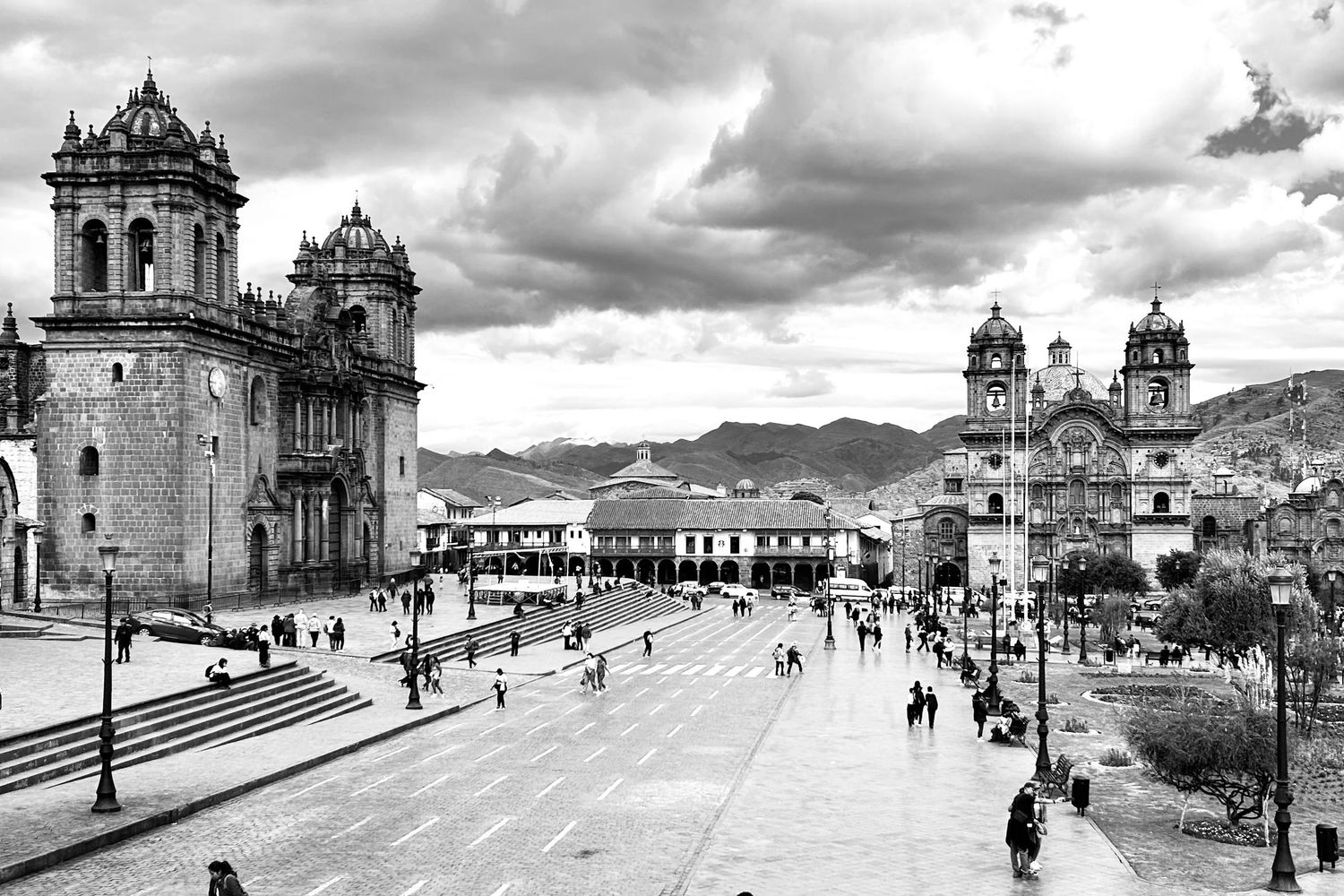 Historic black and white cityscape showing colonial architecture and mountains in the background.