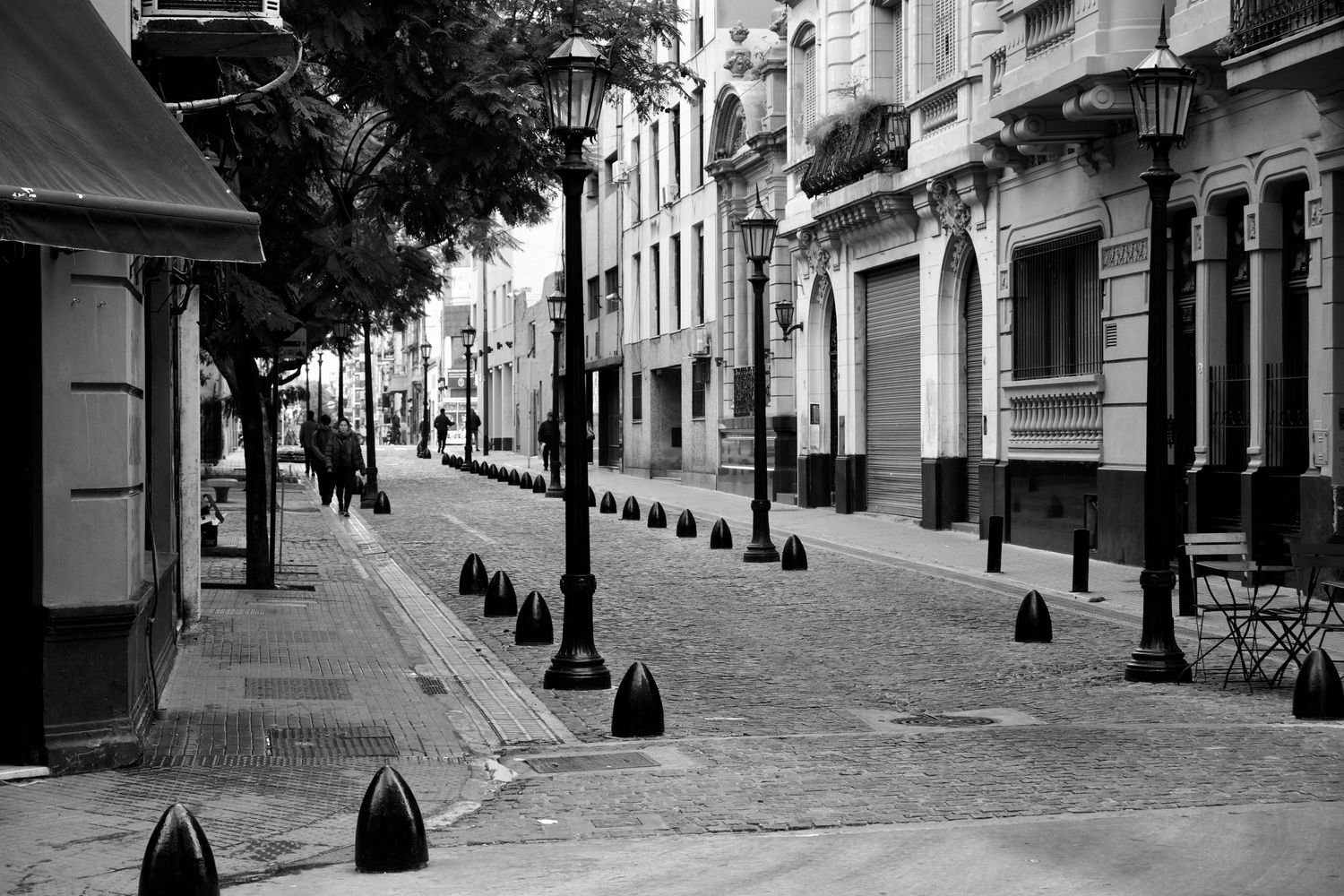 Empty historic European street with traditional architecture and lamp posts.