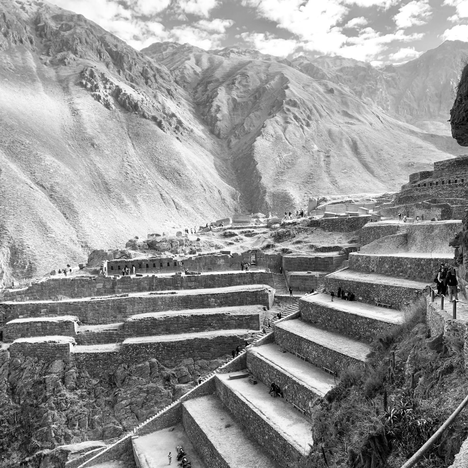 Ancient Incan terraces and stone structures cascade down a mountainside at Ollantaytambo ruins in Peru's Sacred Valley.