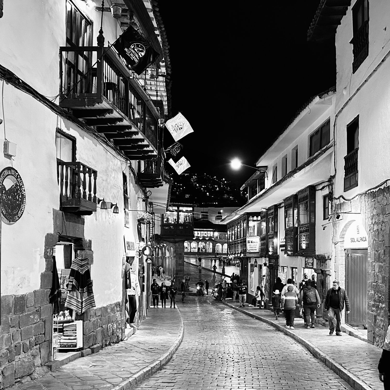 Nighttime view of narrow cobblestone streets in historic city center.