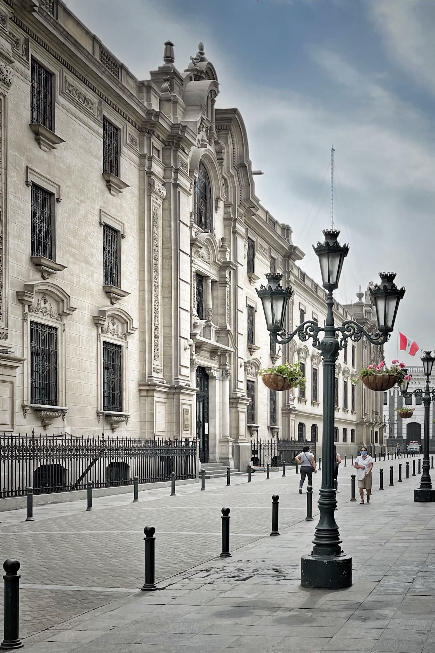 White colonial architecture with ornate lampposts lining a clean empty street.
