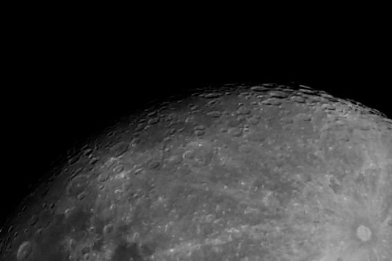 Detailed view of the Moon's cratered surface with visible ridges and shadows cast across the lunar landscape.