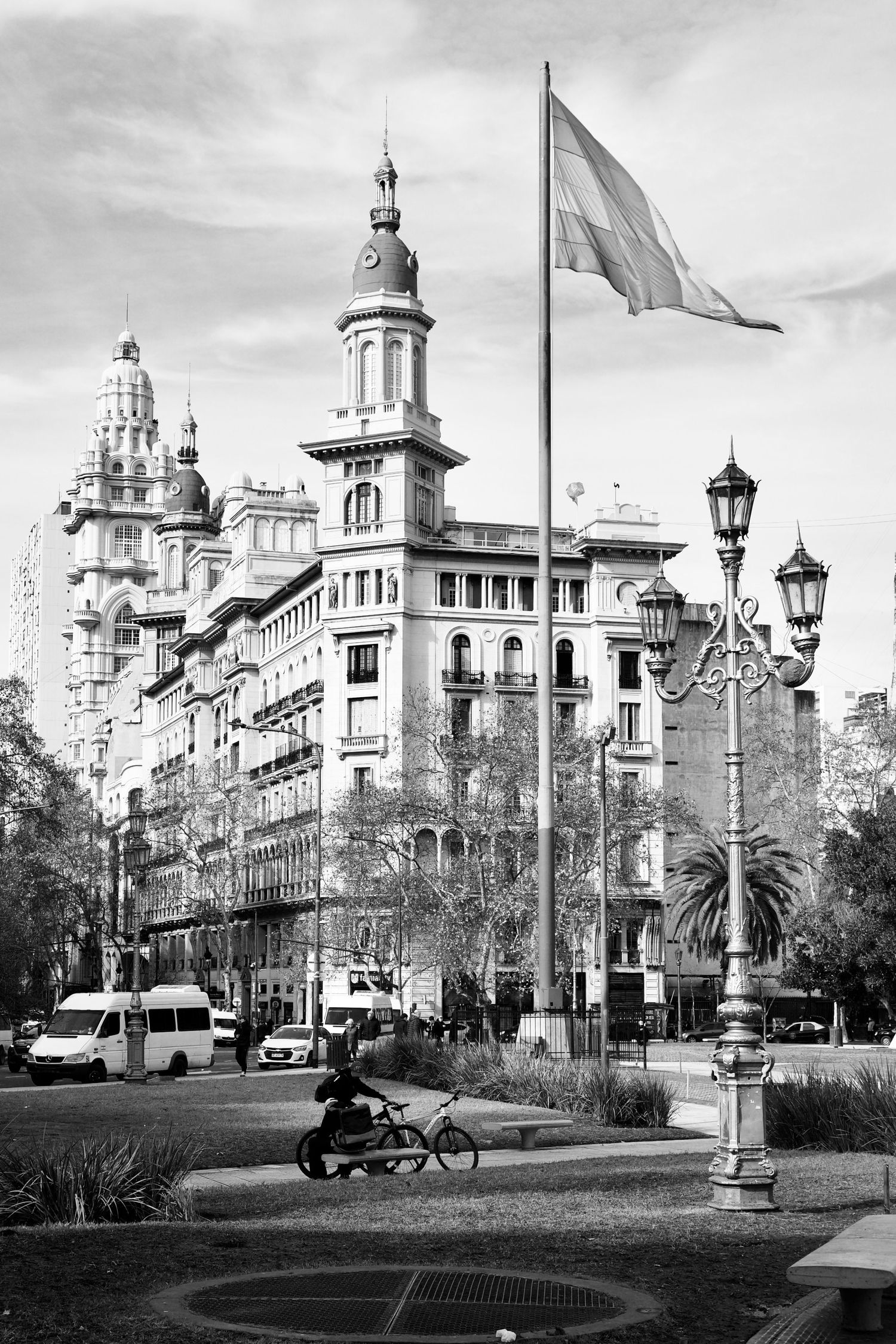Historic buildings with ornate architecture line a palm tree-dotted street in Buenos Aires, Argentina.