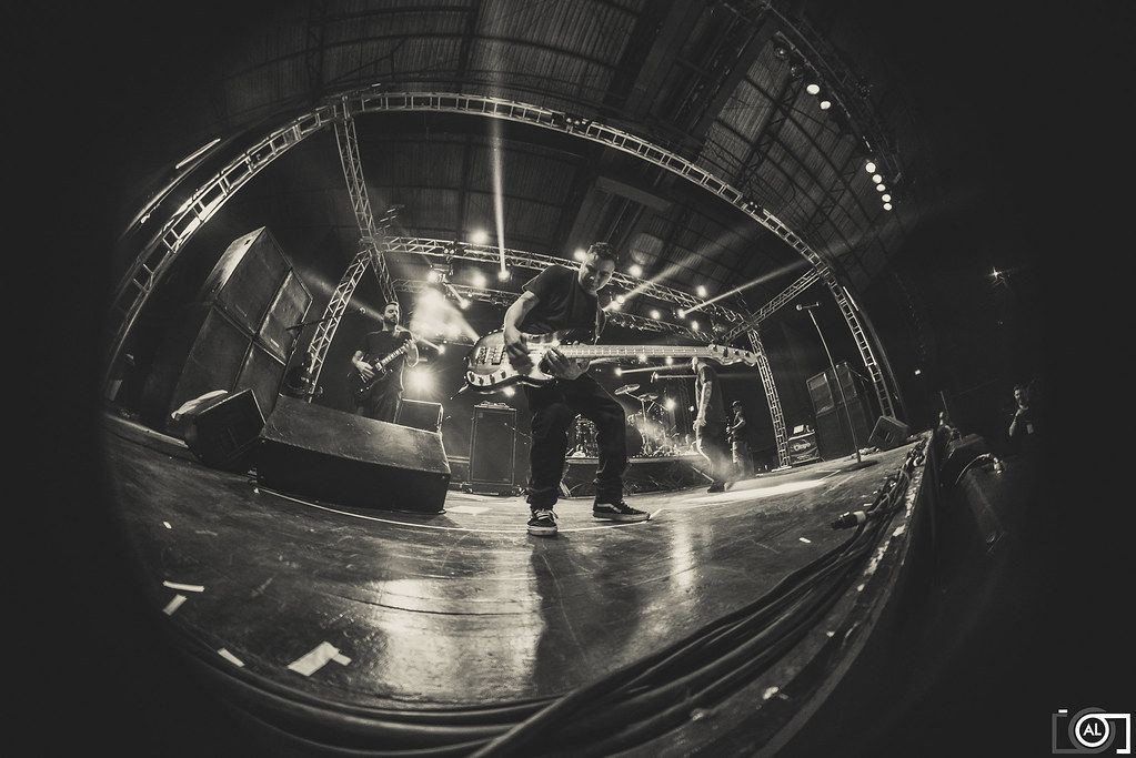 Banda no palco vista em grande angular, em fotografia em preto e branco.