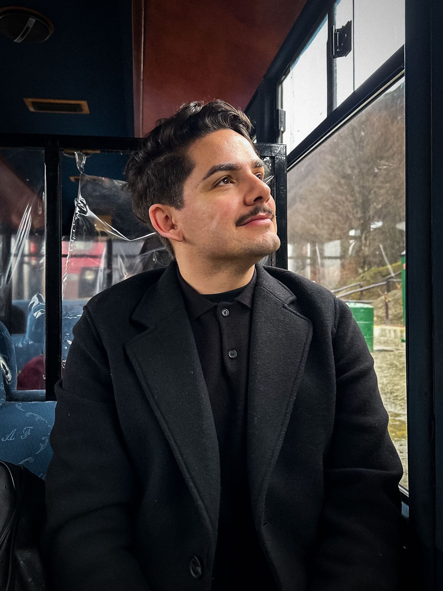 Retrato de Alisson Lüdtke dentro de um ônibus, olhando pela janela.