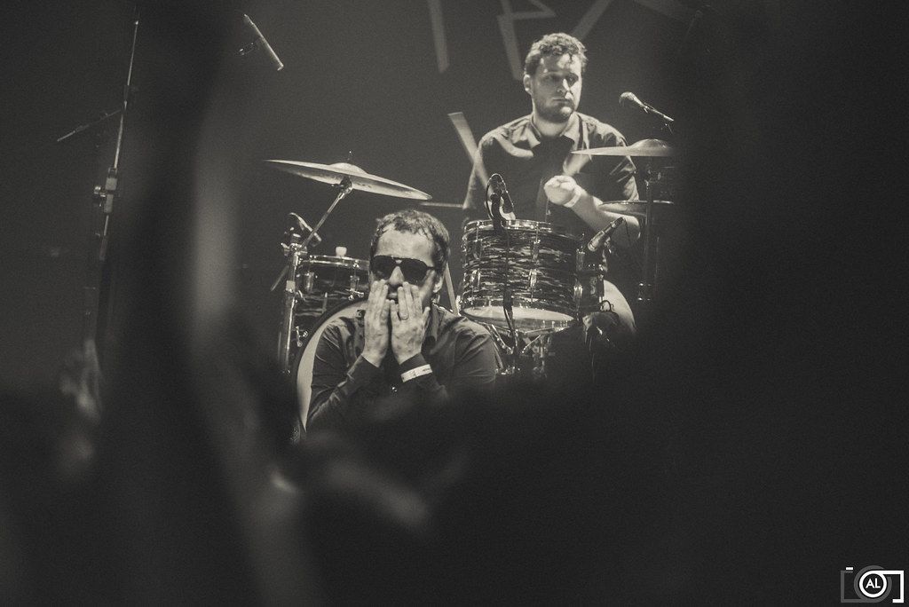 Baterista se apresenta no palco em fotografia em preto e branco.