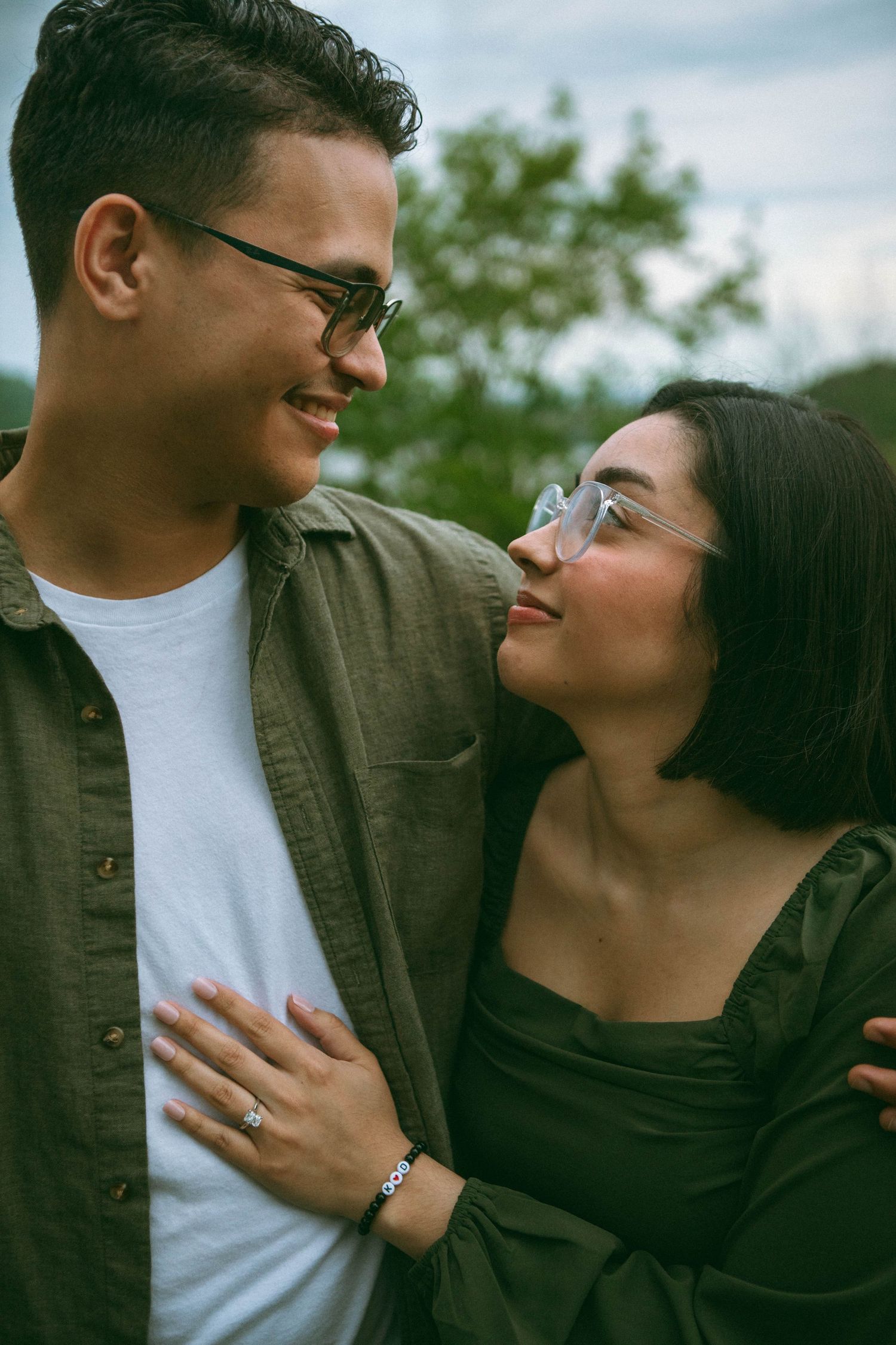 A romantic couple share intimate moments together outdoors in a series of candid photographs during a couples engagement photo shoot