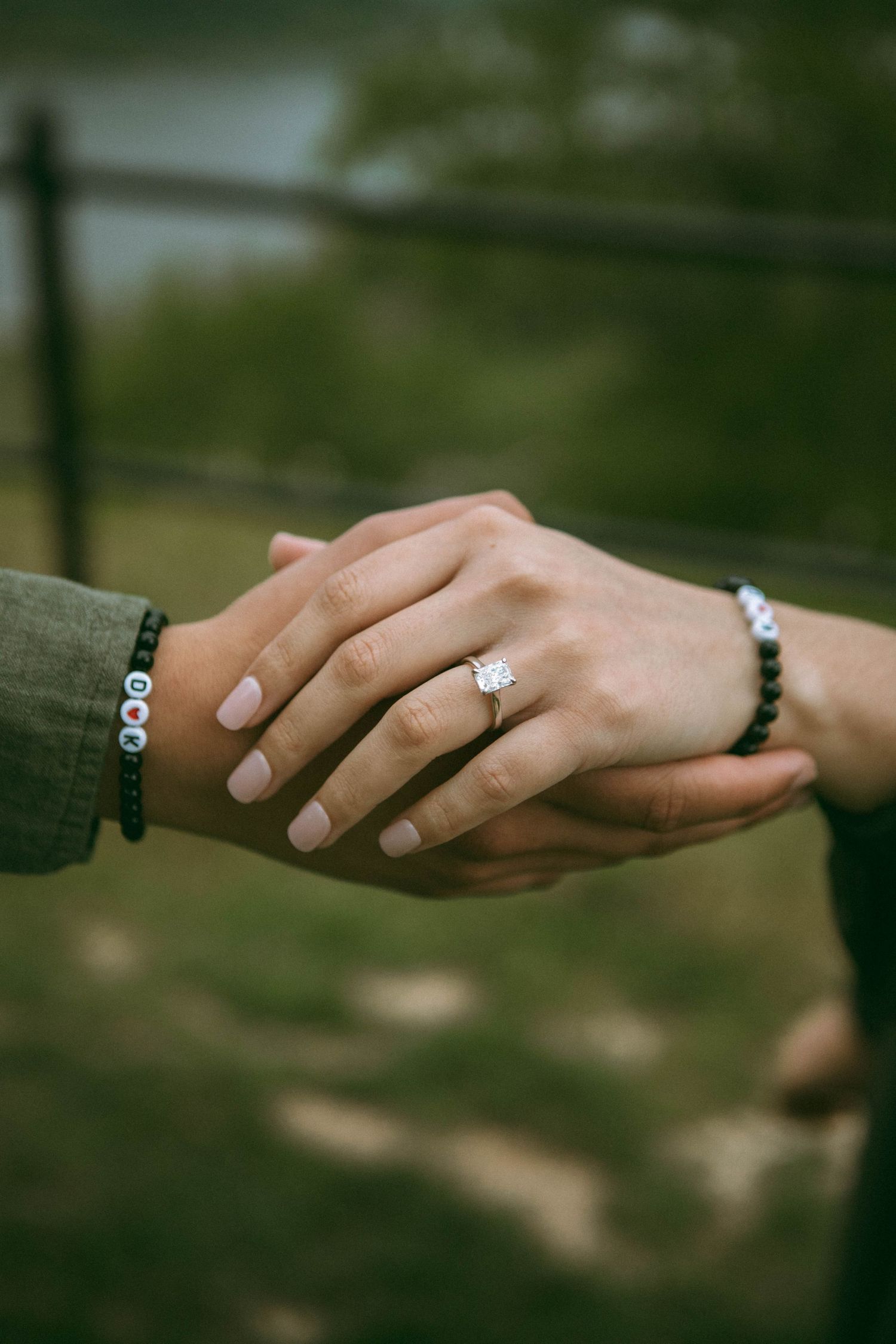 Close-up photo of intertwined hands and an engagement ring showcasing the special moment of a proposal photo shoot by Lancaster Photographer