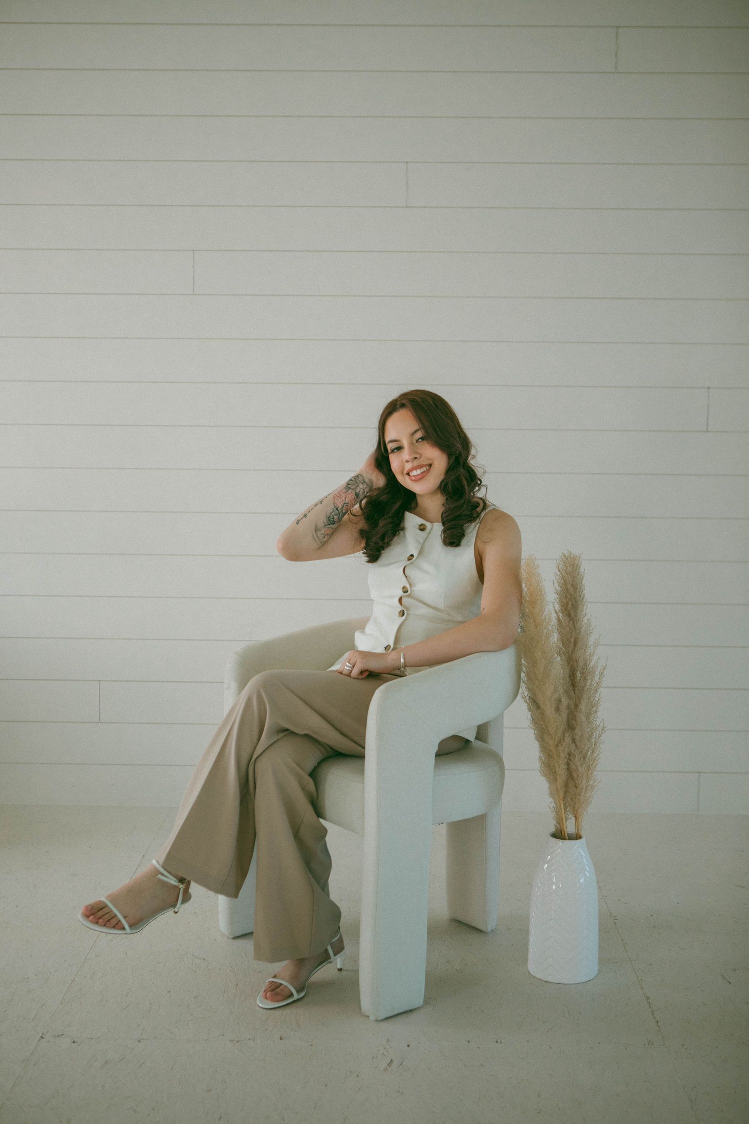 A branding photoshoot of a Lancaster PA realtor sitting down in a minimalist beige studio in New Holland, PA.