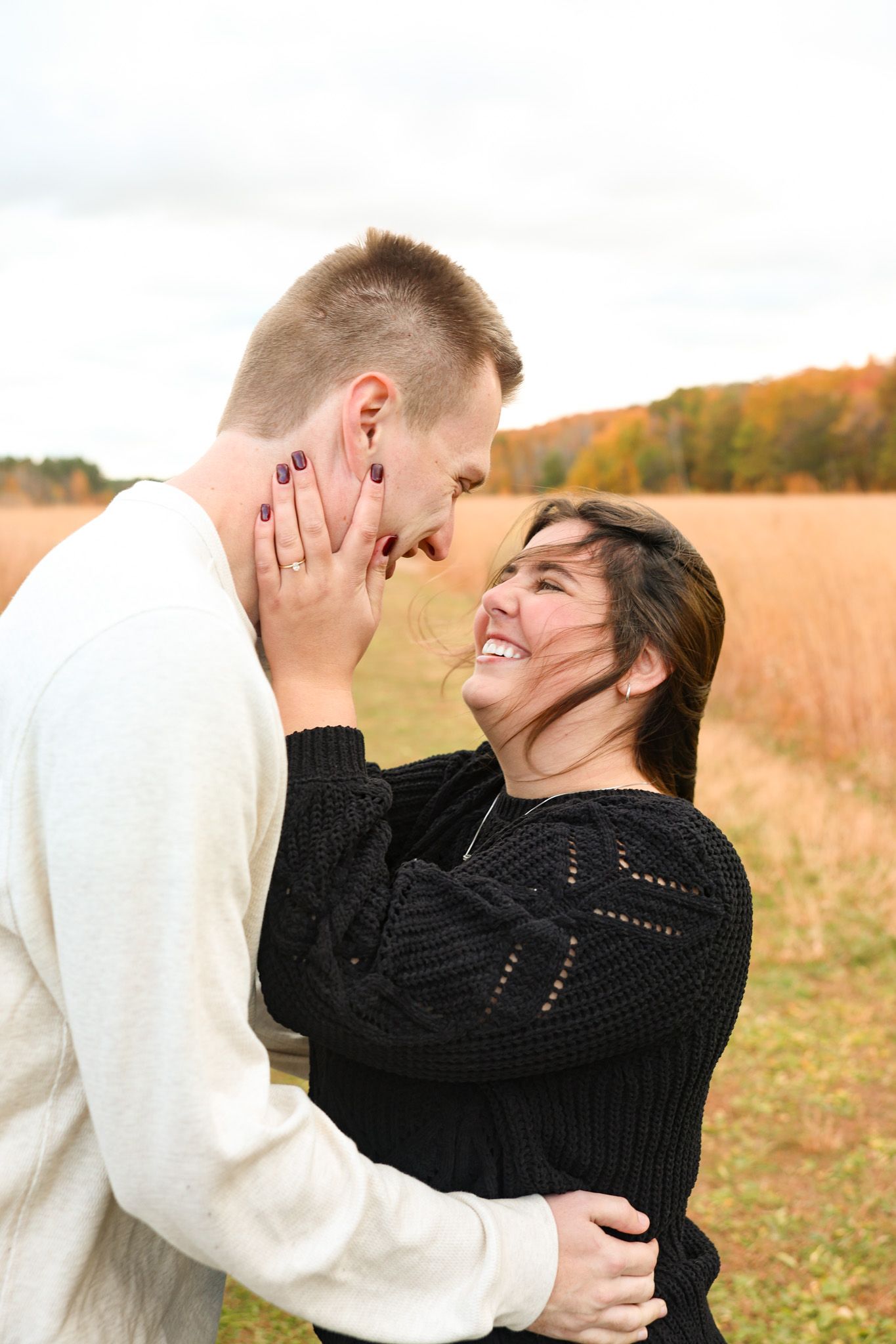 Engagement session with emotion in the wind in the fall.