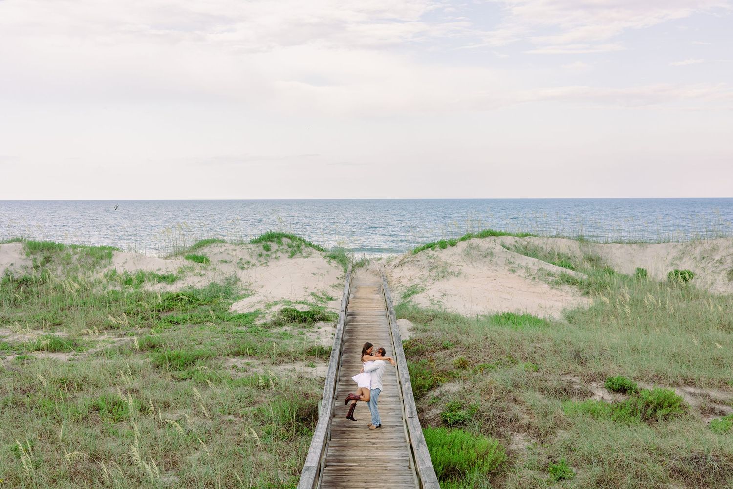 couple embracing on beach boardwalk