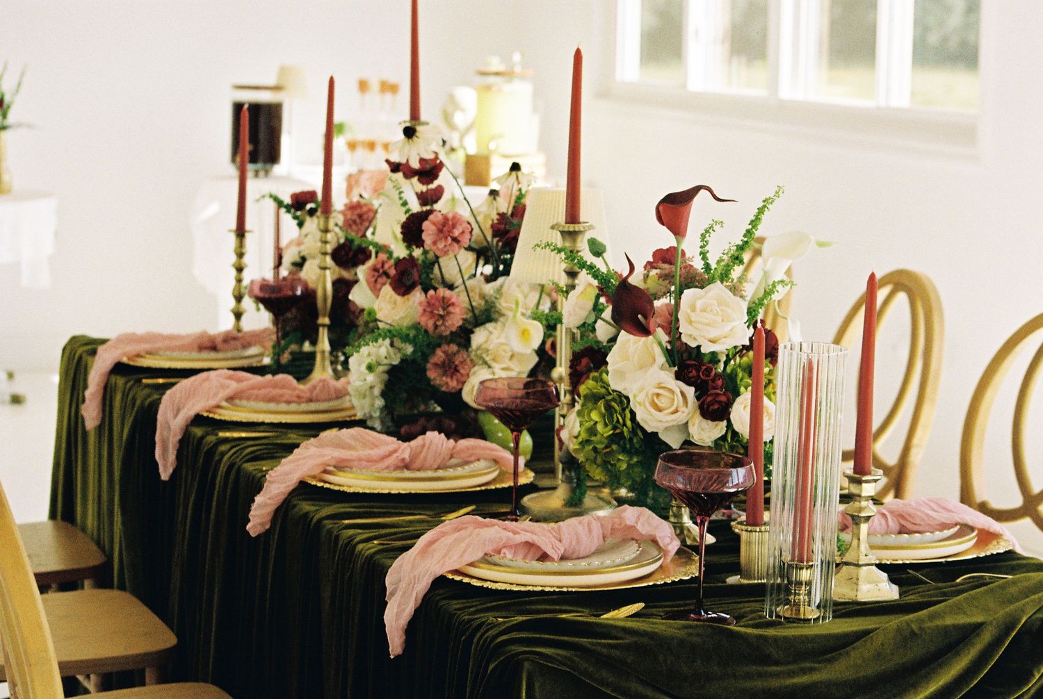 Elegant table setting with pink and white flowers, black linens, and crystal glassware for a formal wedding reception.