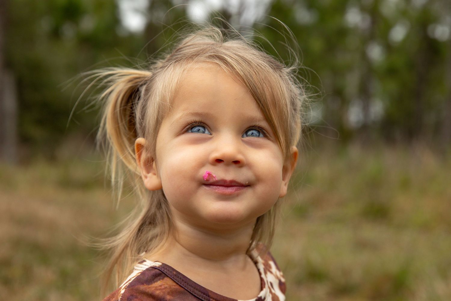A series of seven candid close-up photos showing bright blue eyes and joyful expressions in an outdoor setting.