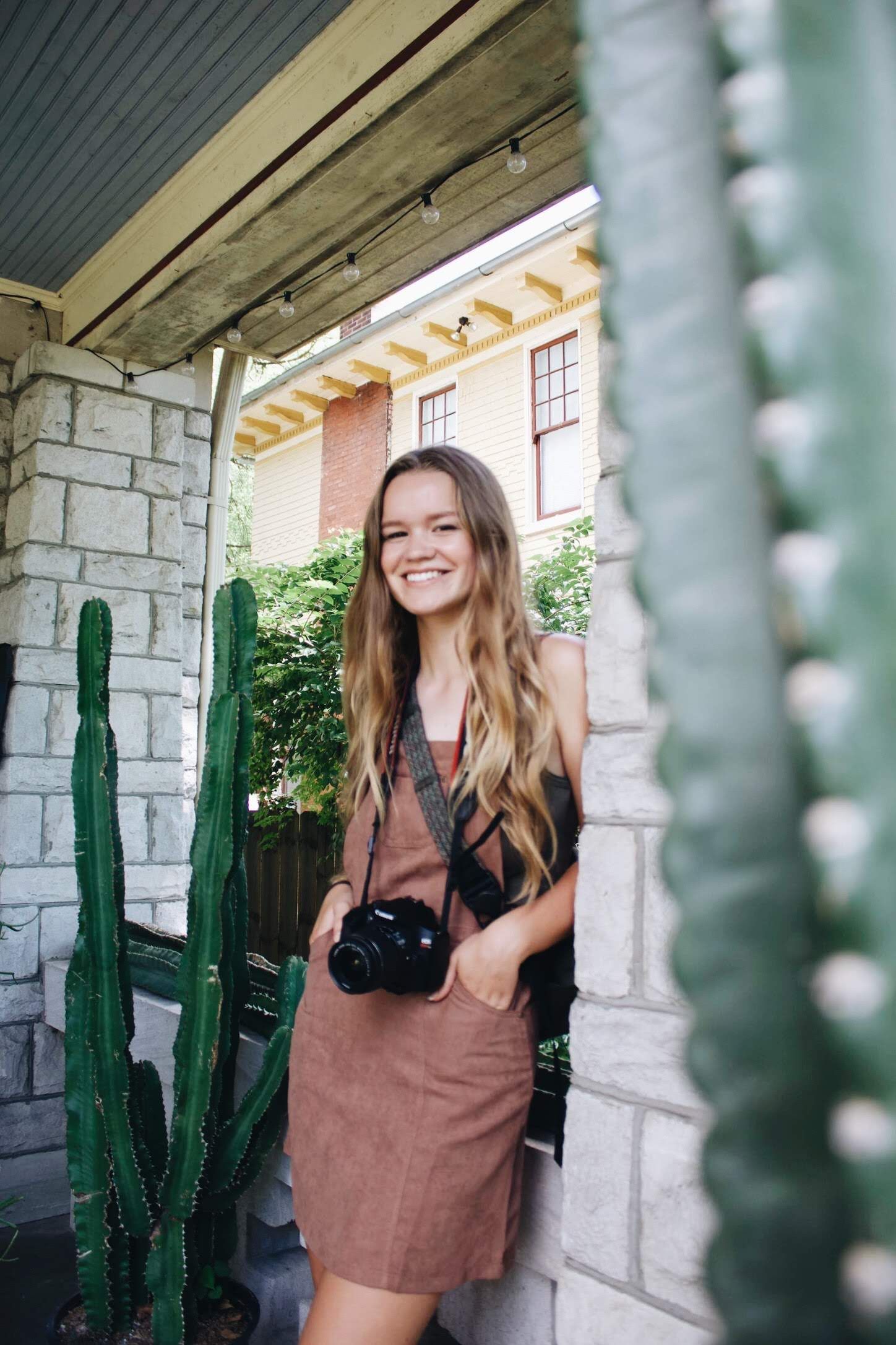 A series of outdoor portraits against a white stone wall with tall cactus plants creating natural framing elements.