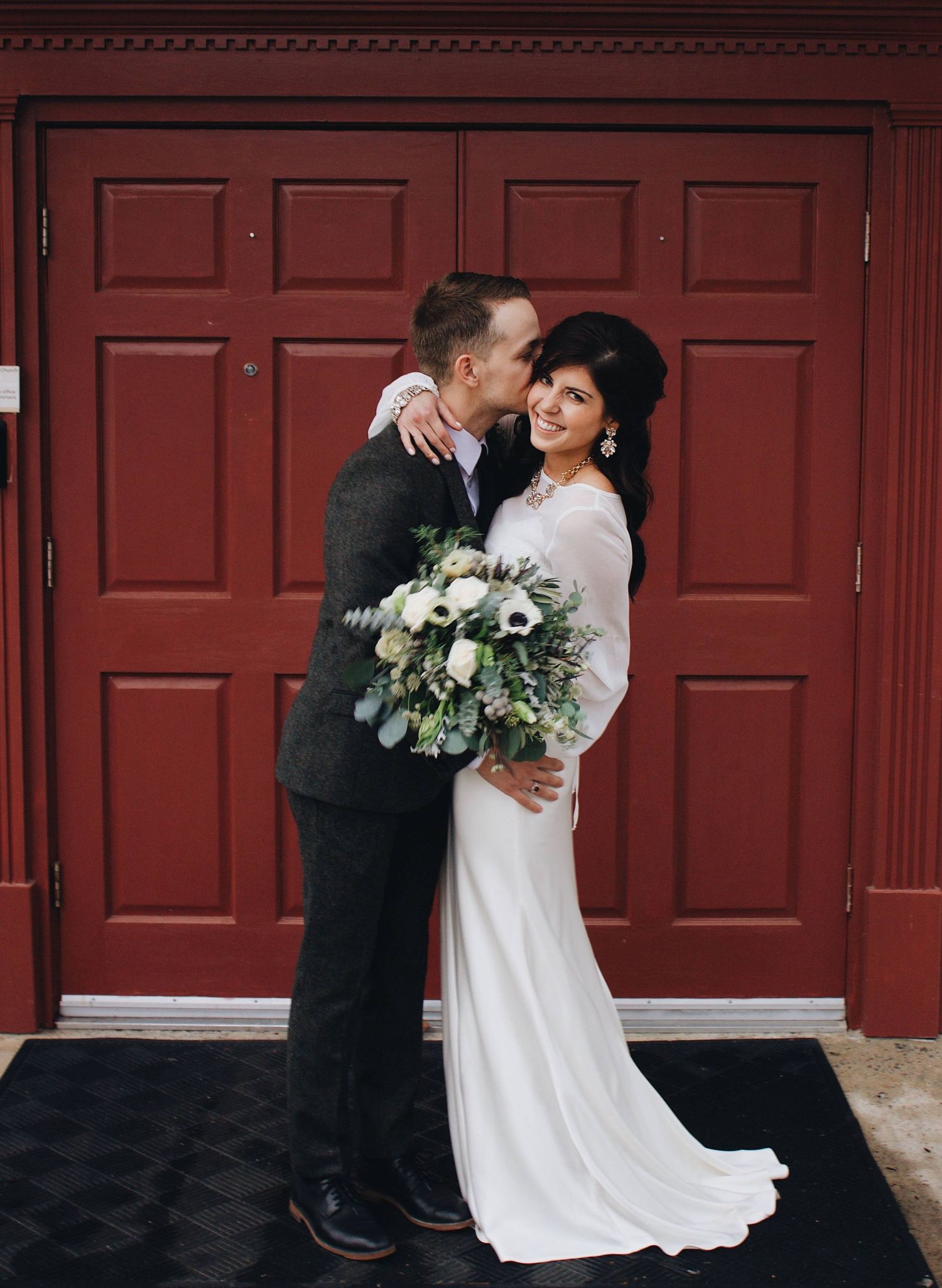 A romantic wedding couple shares intimate moments against a rustic red door backdrop in a series of candid photographs.