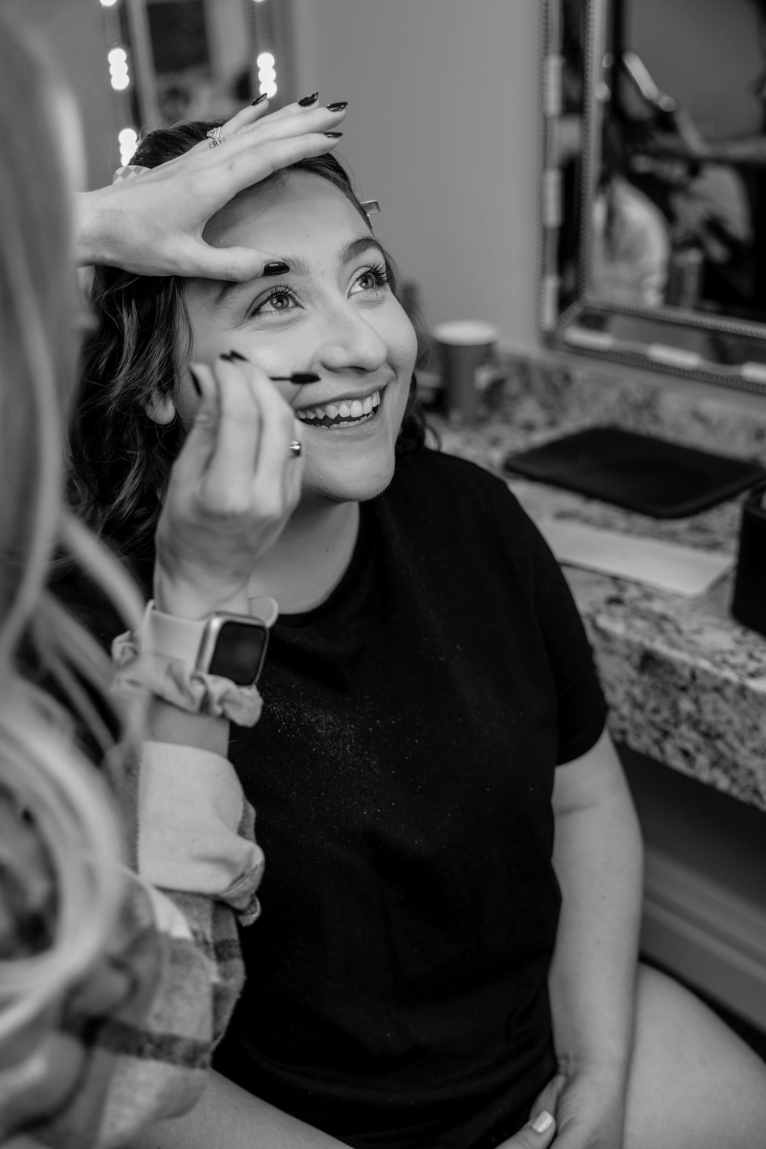 Bride getting make-up done with happy expression in a beautiful getting ready room -
