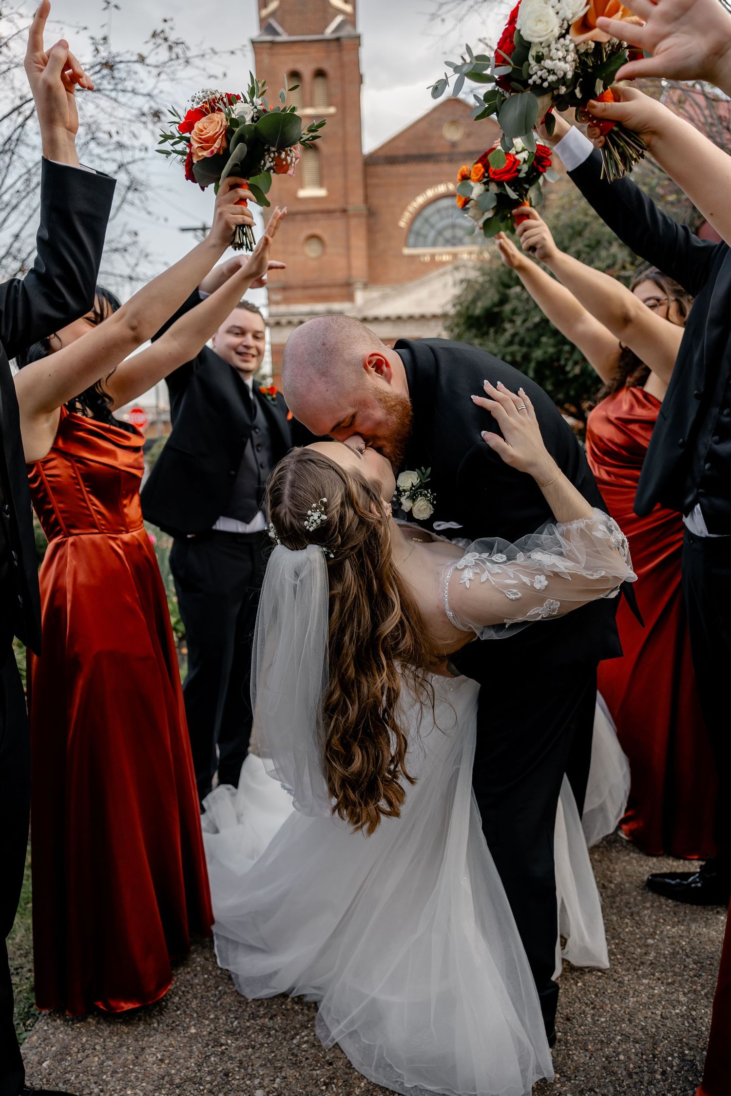 Groom dipping and kissing bride surrounded by joyful wedding party at the Pittsburgh Grand Priory – romantic and candid wedding photography
