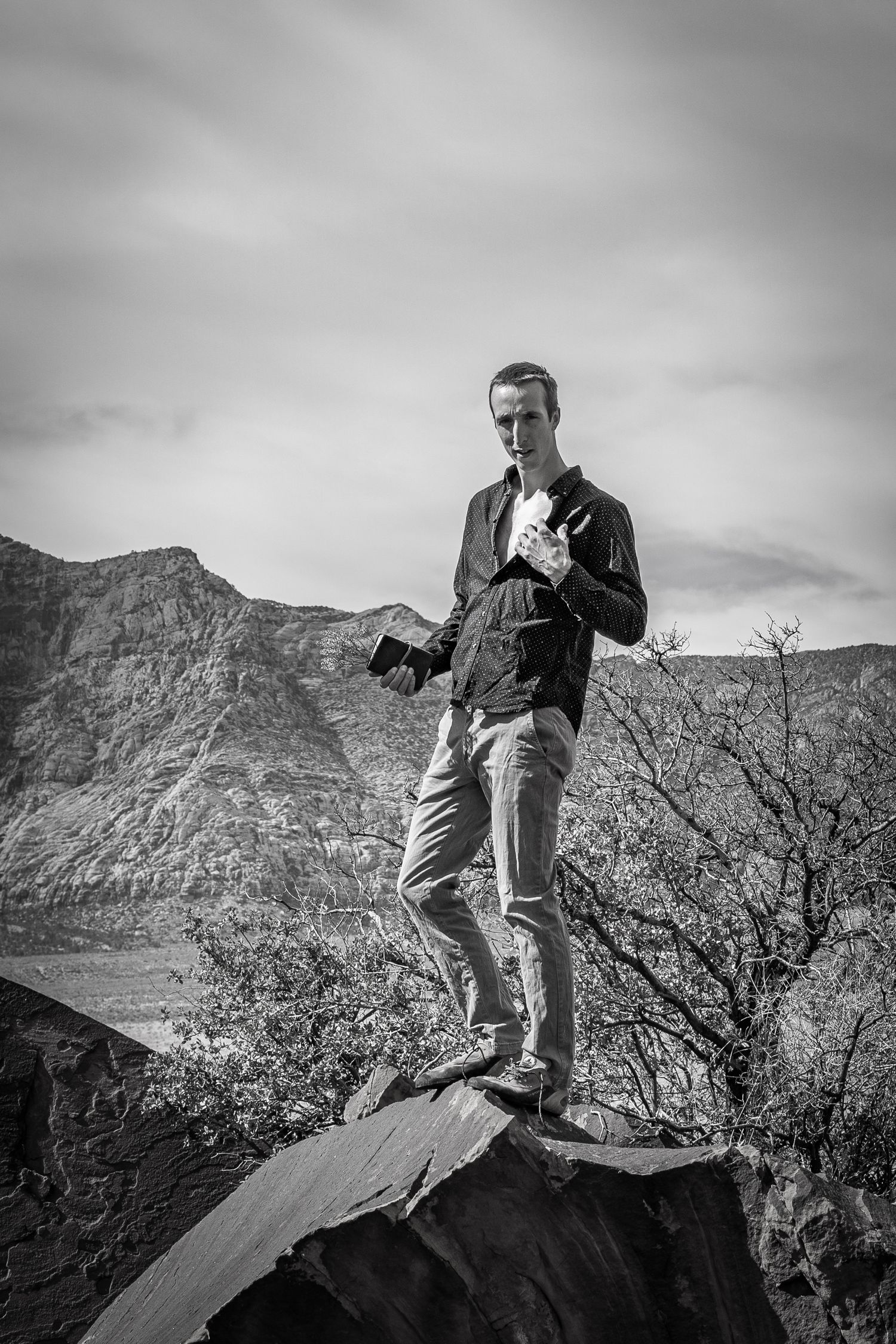 A man being silly, pulling on his shirt in Red Rocks, Nevada.