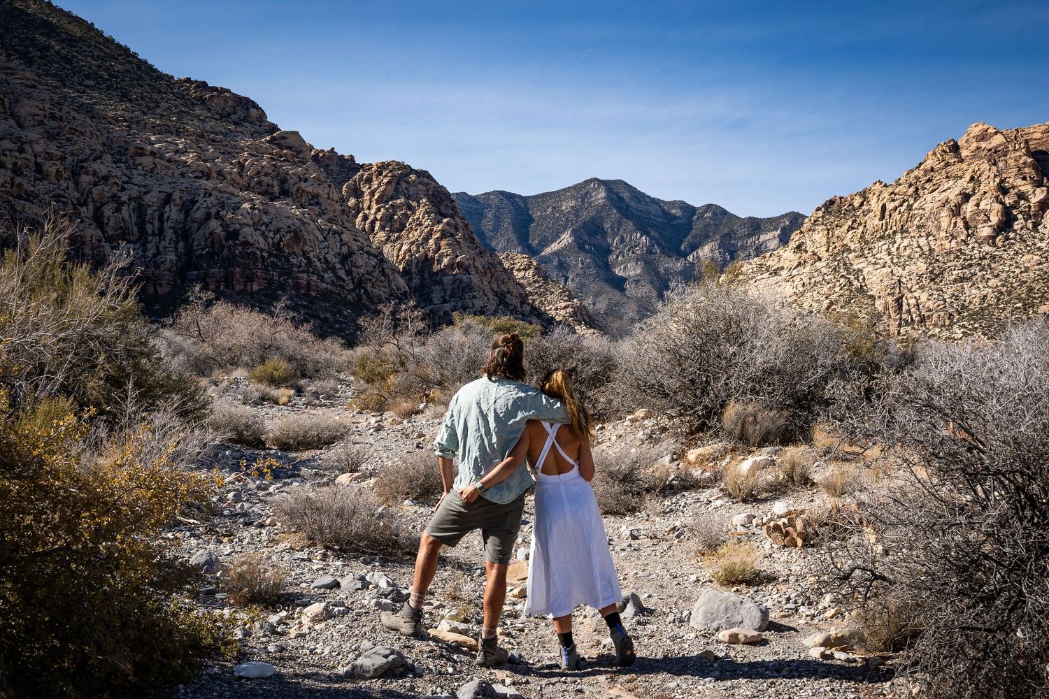 A couple elopes in the mountains of Nevada near Great Basin. They stand and lean against each other looking at the beautiful view.
