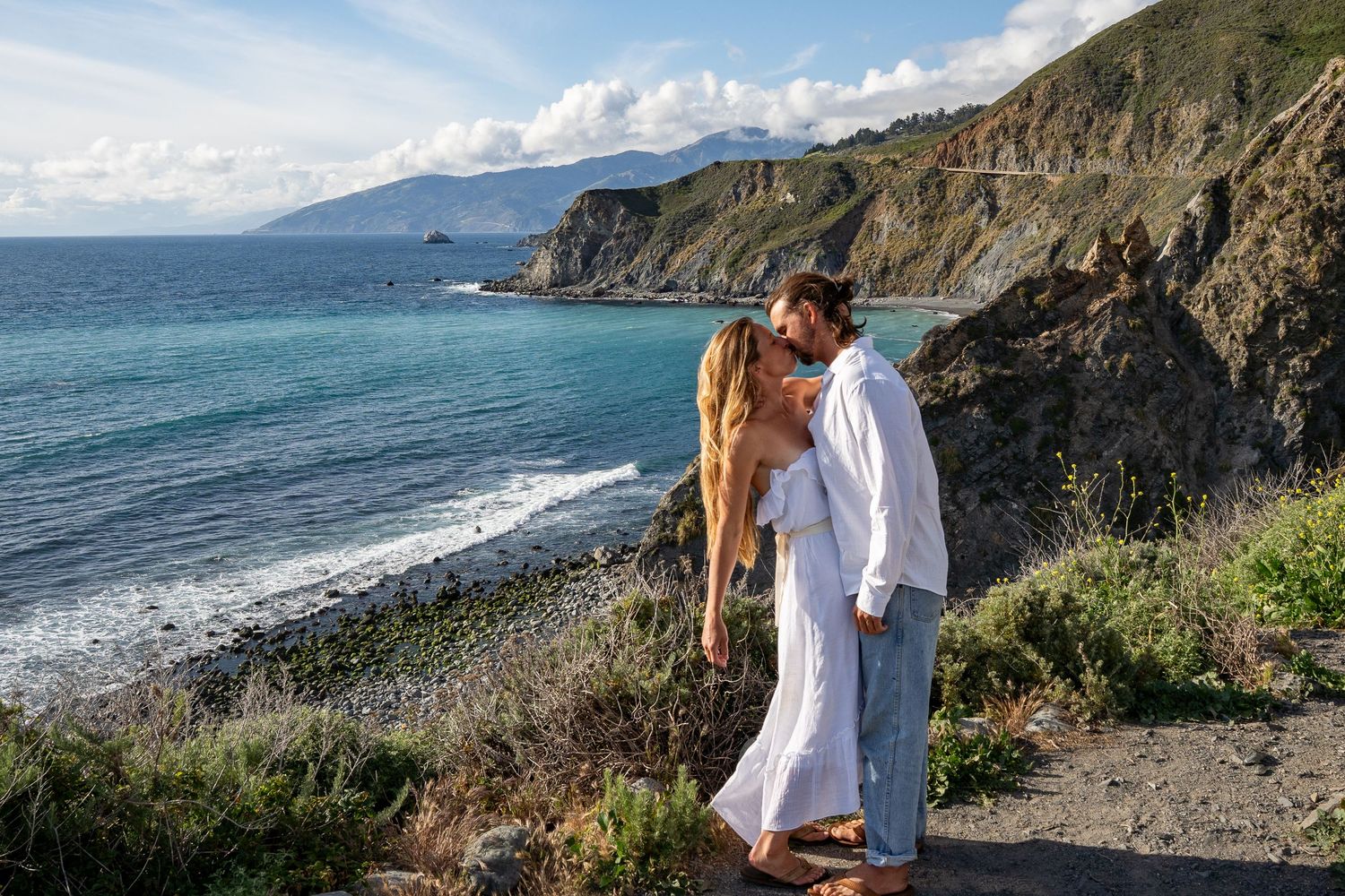 A couple kisses on the cliffs of Big Sur on their elopement day.