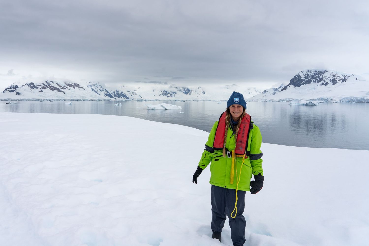 Madison, the photographer from Mad Elopements, poses in the snow in Antarctica.
