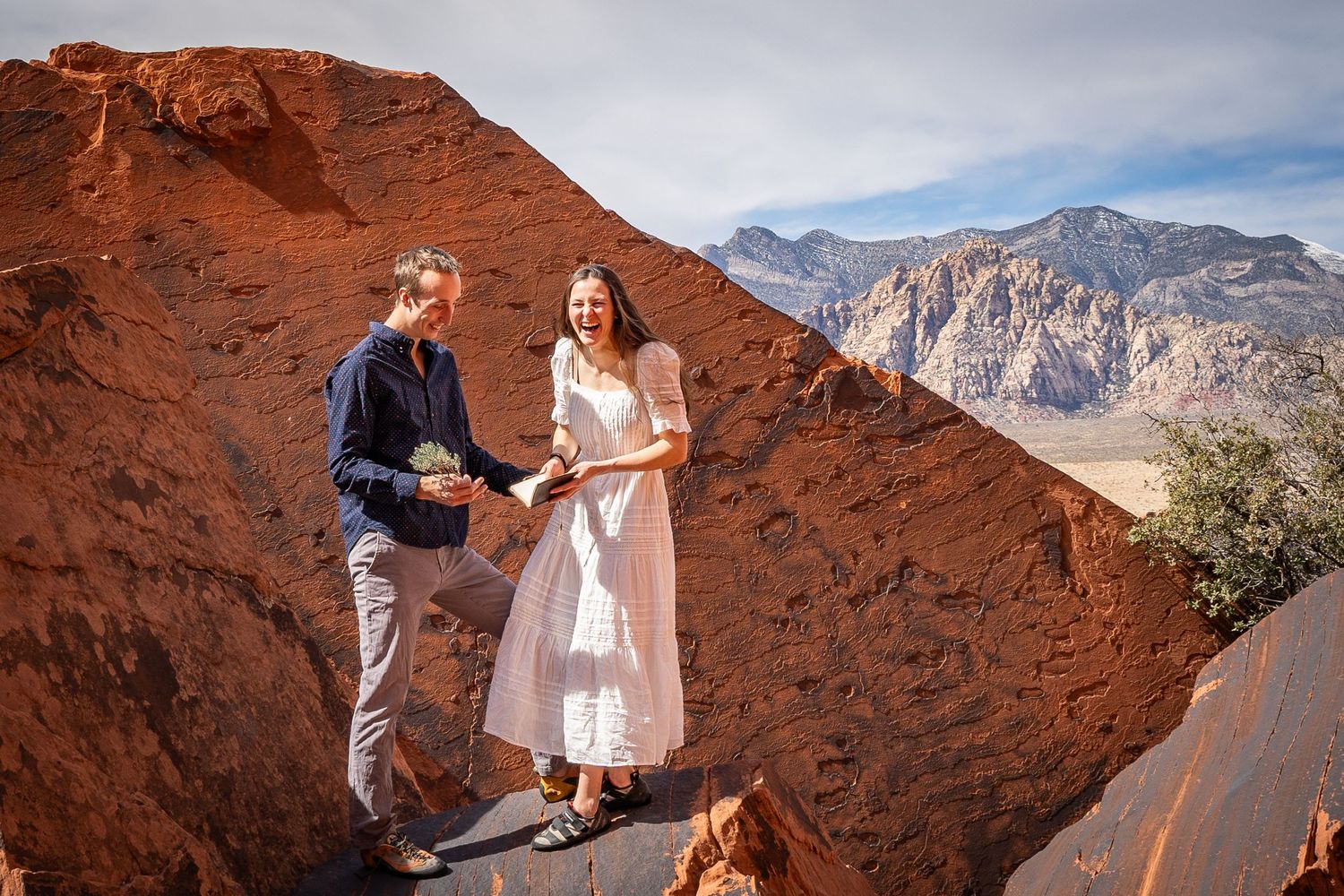 A couple laughs on their elopement wedding day in Red Rocks Nevada. They spent their wedding day climbing and exploring.