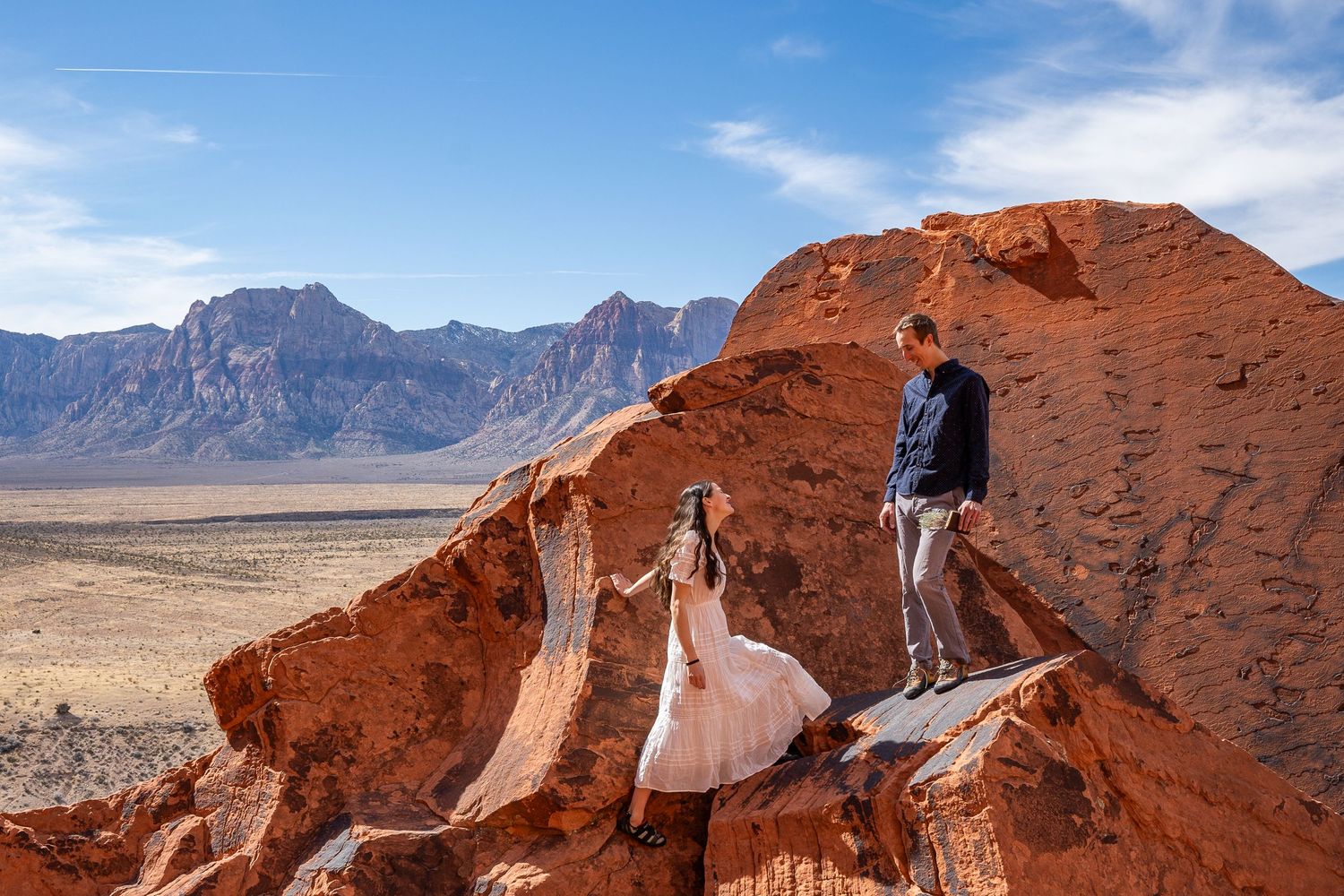 A couple climbs rocks on their elopement wedding day in Red Rocks Nevada. They wore their climbing shoes during their ceremony.