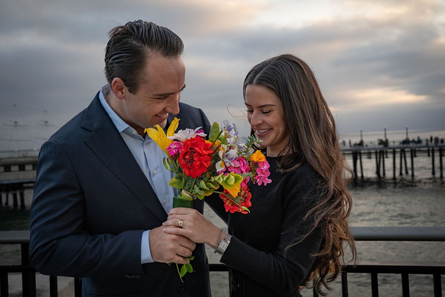 A beautiful couple admires their bouquet on their elopement day in Redondo Beach.