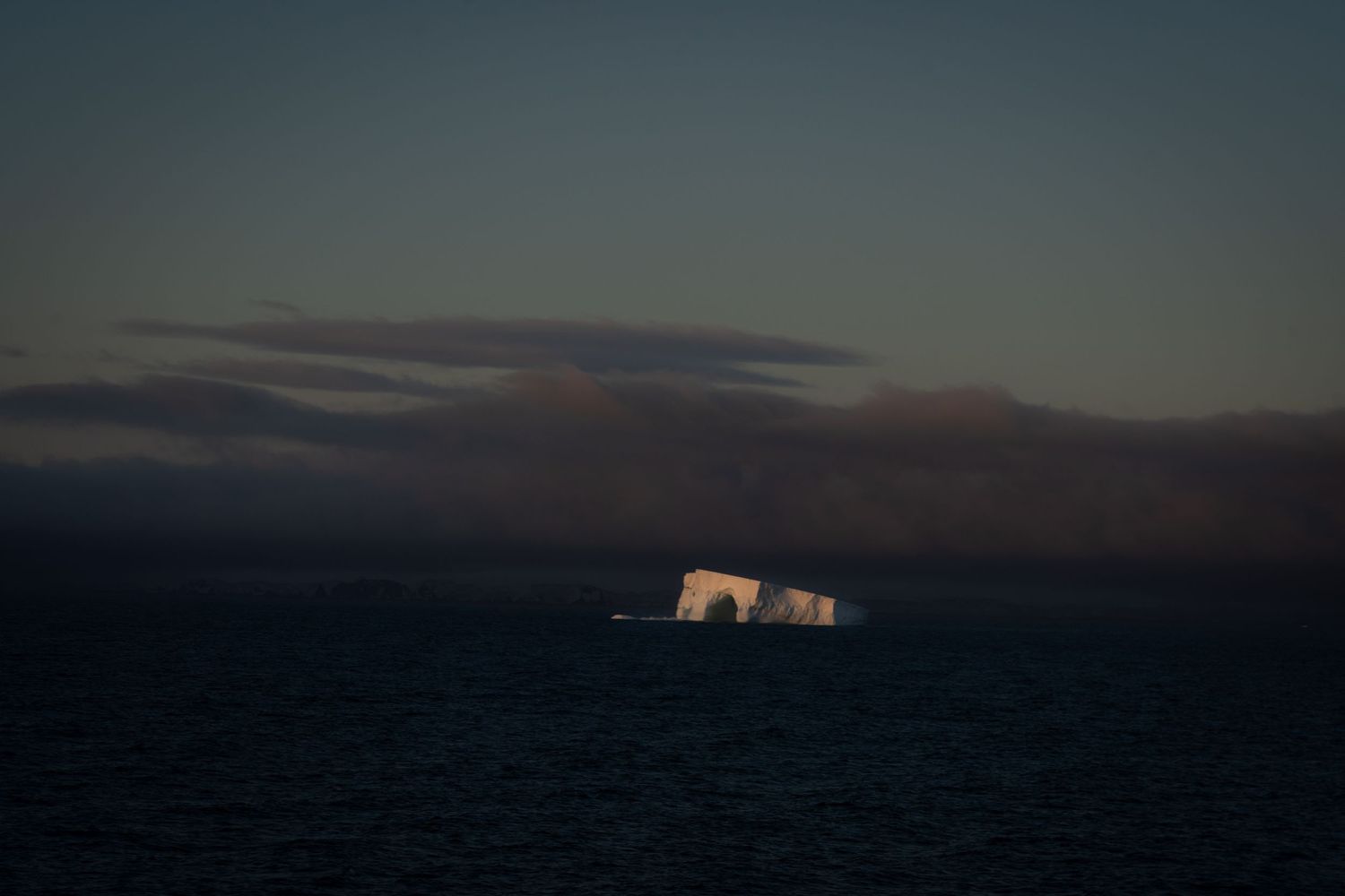 Hauntingly beautiful lone iceberg at sunset in Antarctica.
