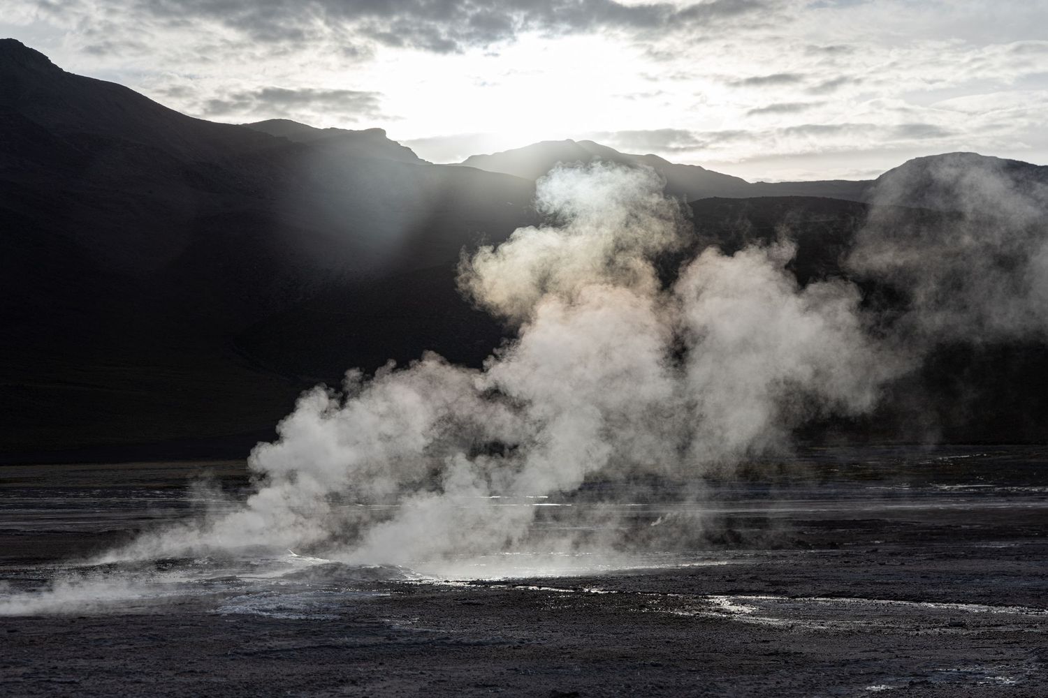 A geyser erupts in moody predawn lighting in San Pedro de Atacama, Chile. This would be a creative place to get married.