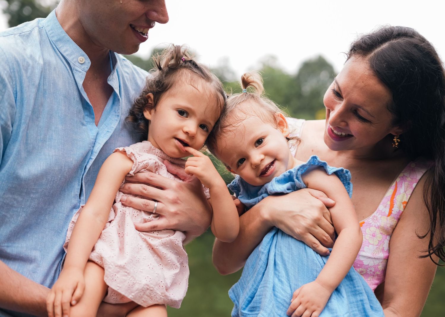 A family shares joyful moments together outdoors near a lake.